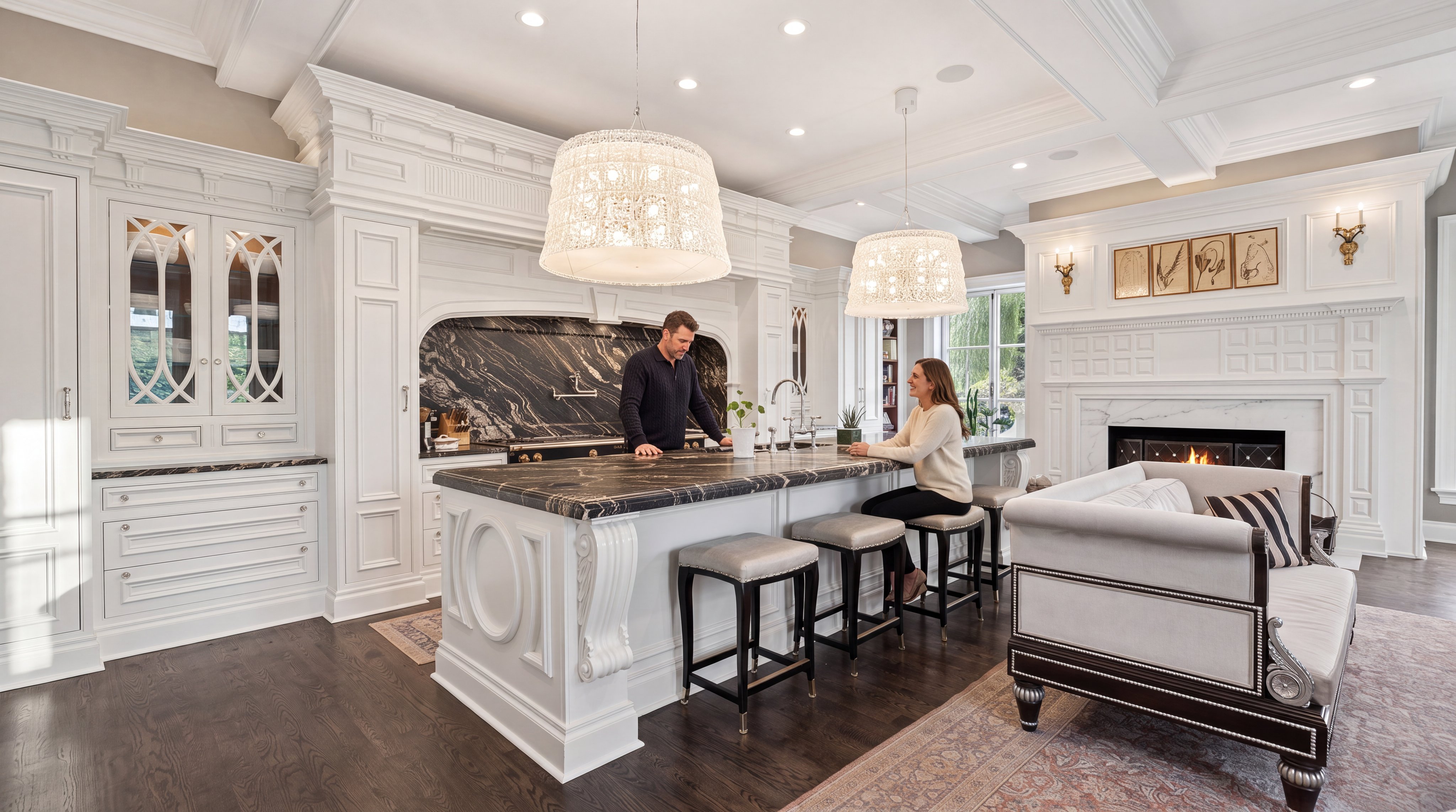 This luxurious, high-end kitchen features white custom cabinetry and a stunning black marble island that serves as both a workspace and a social hub. The room is accented by grand, intricate pendant lighting, a built-in fireplace, and a sophisticated lounge area, creating an elegant blend of culinary function and living room comfort. With its rich dark hardwood floors and professional-grade details, this space exudes a classic, refined aesthetic ideal for entertaining.