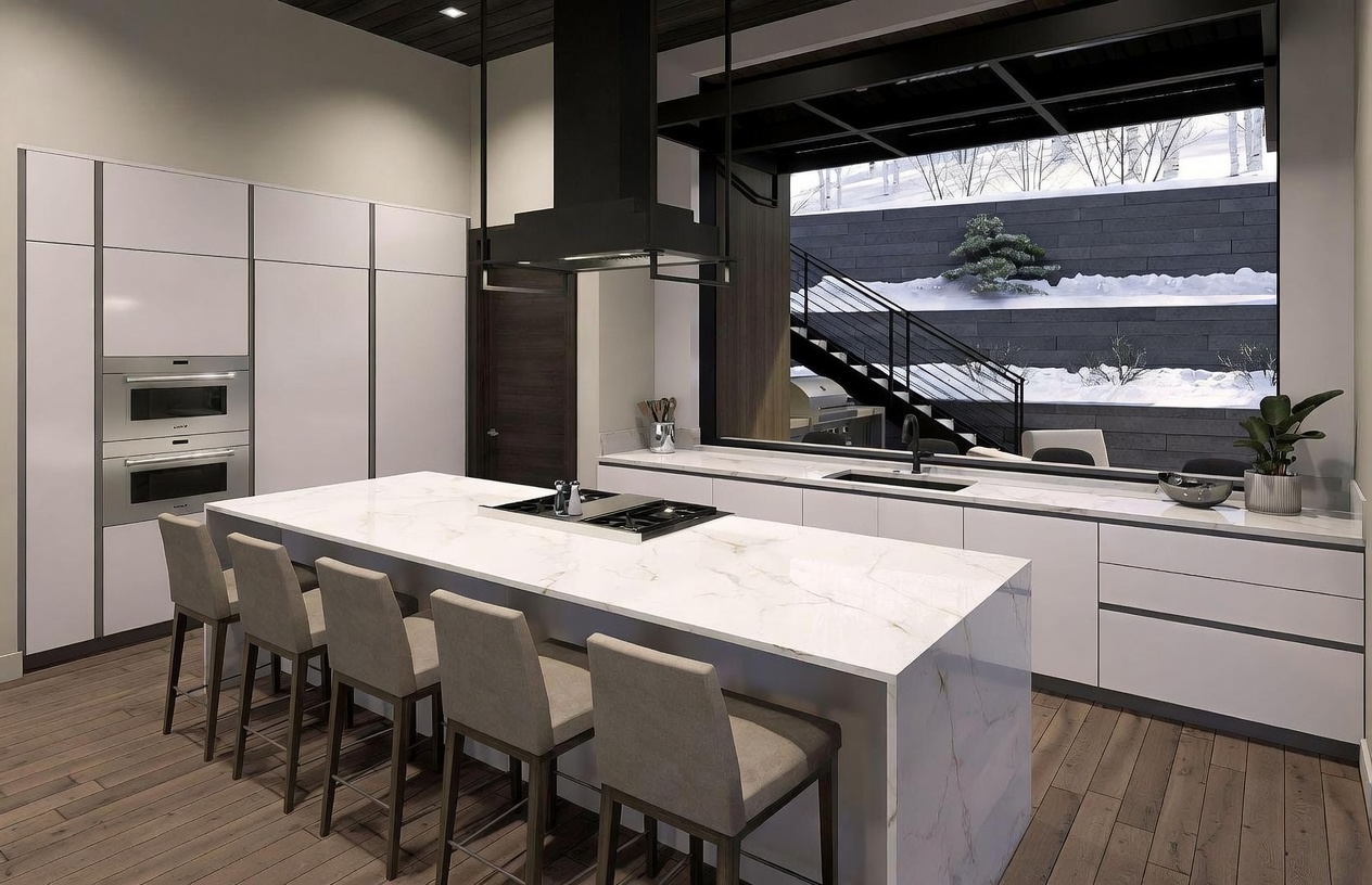 This modern kitchen features a large central island with a stone countertop and integrated cooktop, surrounded by four bar stools. The space is defined by sleek, minimalist cabinetry and high-end built-in appliances, while a large window provides a direct view of a snowy outdoor staircase and tiered retaining wall. The design emphasizes clean lines and a sophisticated, contemporary aesthetic with a neutral color palette.