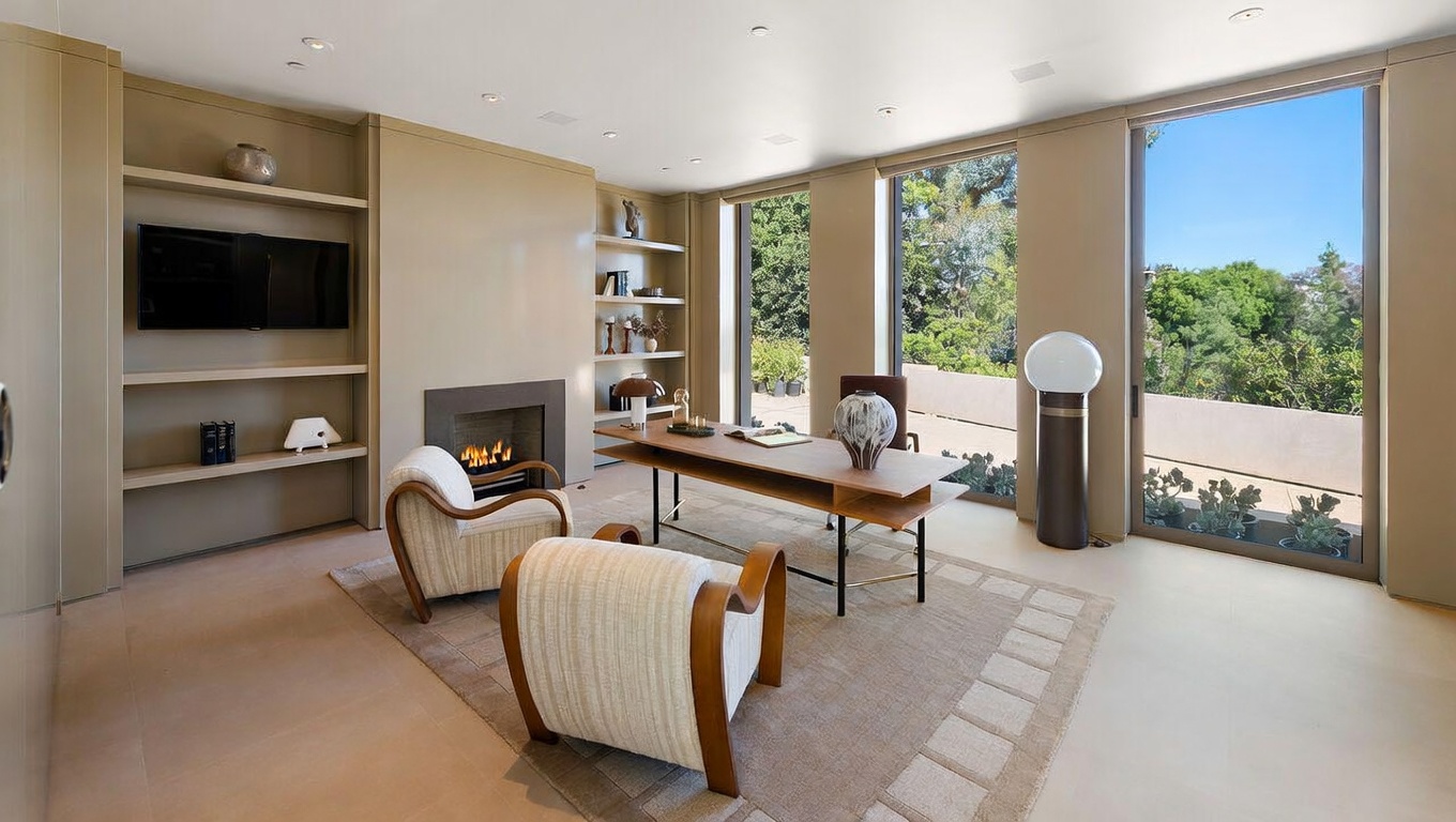 This sophisticated home office features a minimalist, modern aesthetic with warm beige tones and clean lines. The room is anchored by a sleek wooden desk and two comfortable, curved armchairs, complemented by built-in shelving and a cozy fireplace. Large floor-to-ceiling windows provide abundant natural light and a serene view of the lush greenery outside, creating a tranquil and productive workspace.