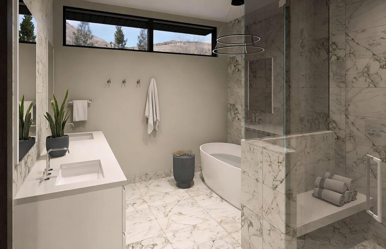 This modern primary bathroom features a sleek double vanity with a potted plant and a large, freestanding soaking tub positioned near a horizontal window. A glass-enclosed shower area with a built-in bench and patterned stone wall tiles adds a luxurious touch to the space. The room is finished with light-colored stone flooring, creating a bright and sophisticated atmosphere.