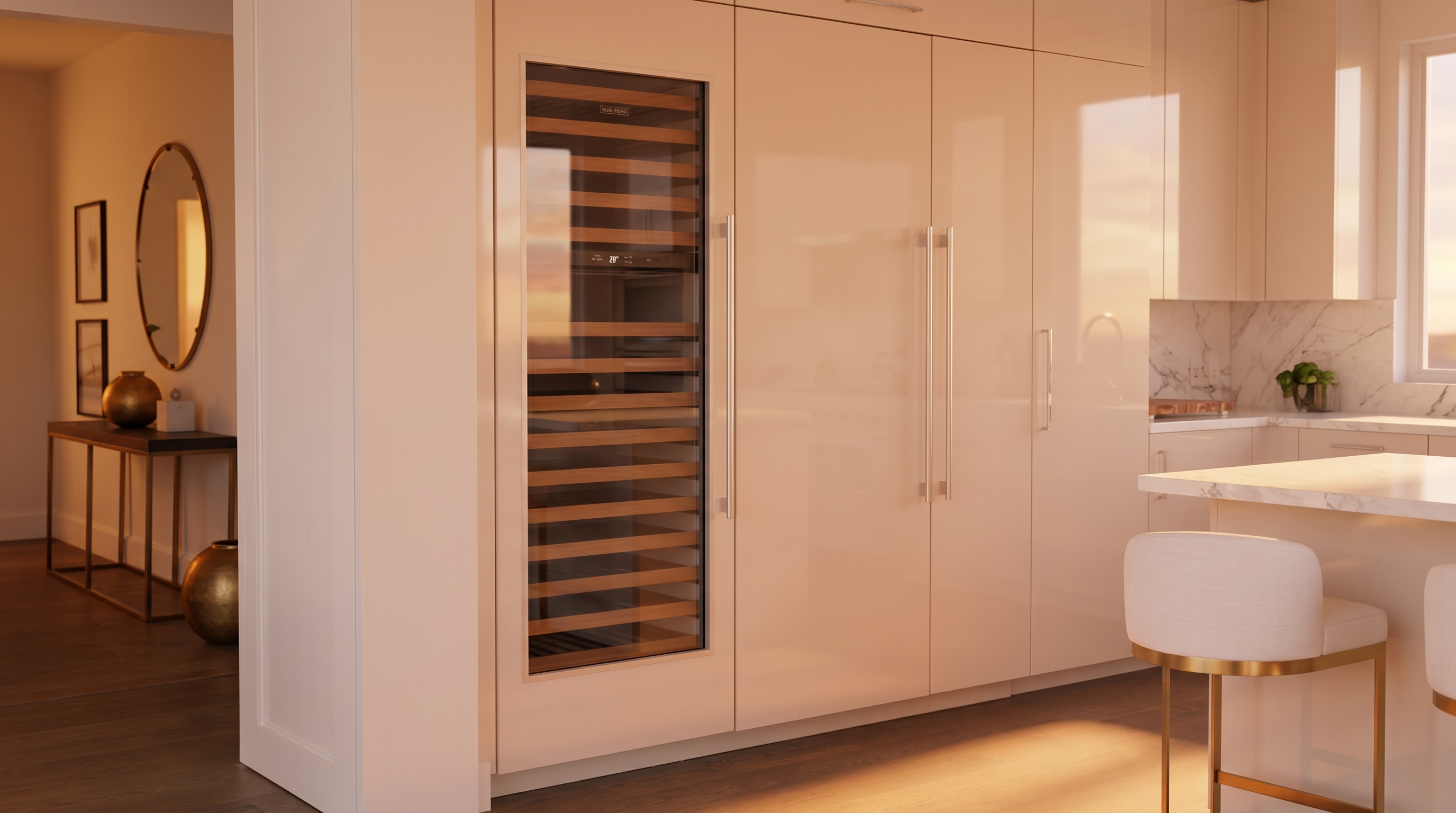 This sleek, modern kitchen features high-end integrated appliances including a built-in wine refrigerator with wooden shelving. The seamless, glossy cream-colored cabinetry provides a minimalist aesthetic, complemented by clean lines and contemporary bar stool seating at a kitchen island. The space is bright and sophisticated, showcasing premium finishes and an open-concept flow into the adjacent living space.