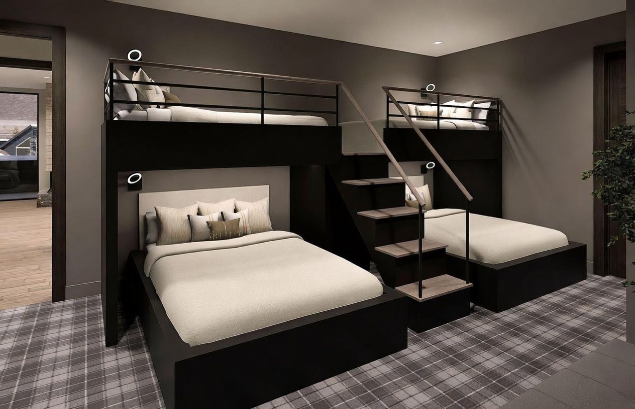 This modern bedroom features a custom-built bunk bed configuration with a lower queen-sized bed and an upper twin bunk, complemented by a separate twin bed accessed by a central staircase. The room is styled with a neutral color palette, dark wood frames, and a classic plaid carpet, creating a cozy and functional sleeping space. The perspective is a wide-angle shot that captures the entire built-in structure, highlighting the efficient use of space for multiple occupants.