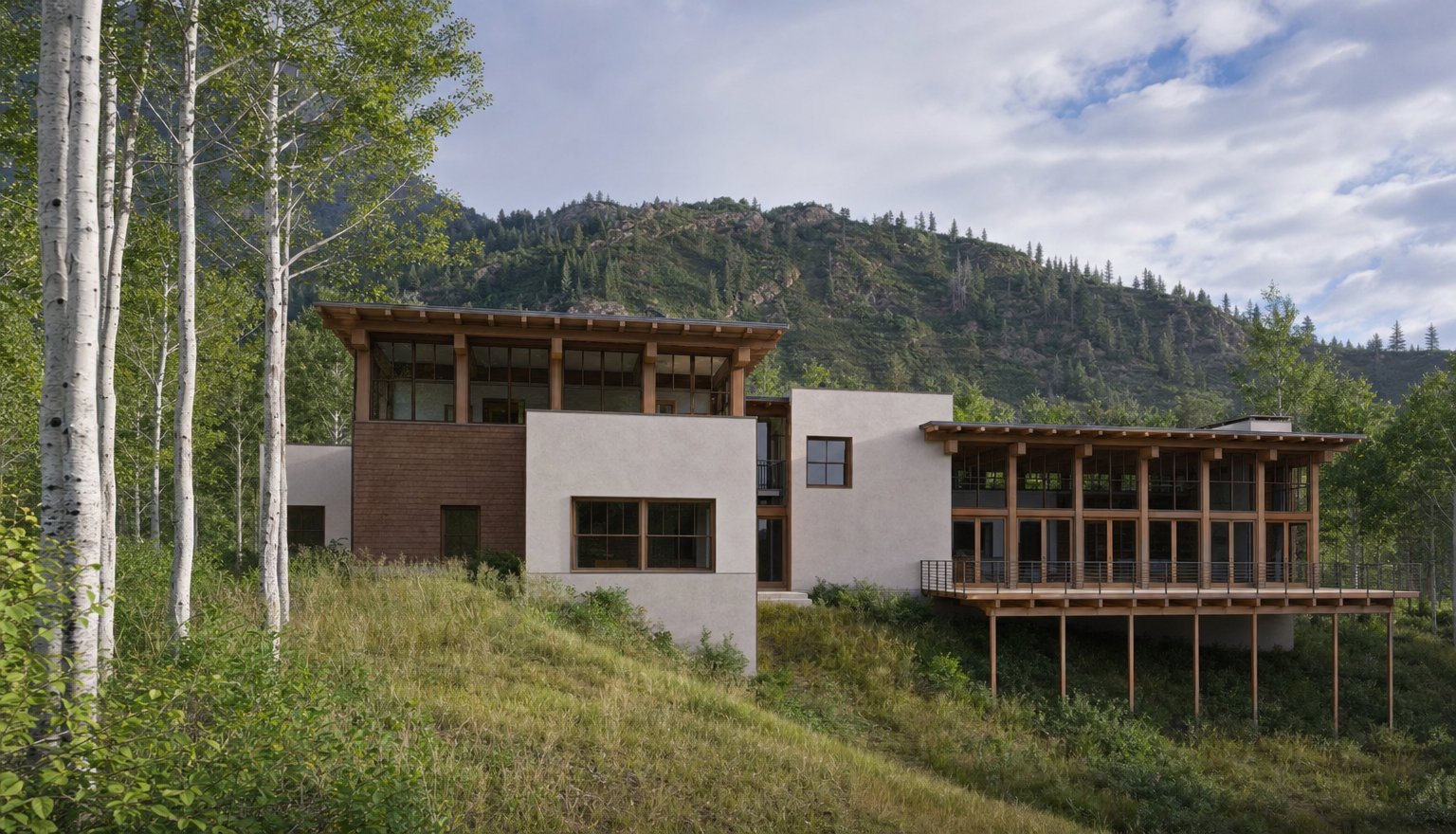 This architectural rendering showcases a modern mountain residence nestled into a sloped, wooded landscape. The home features a sophisticated blend of light-toned stone masonry, warm wood siding, and expansive glass walls that open onto a large, elevated wooden deck. The structure's tiered, flat-roof design emphasizes horizontal lines, creating a seamless integration with the surrounding aspen trees and the rugged mountain backdrop.