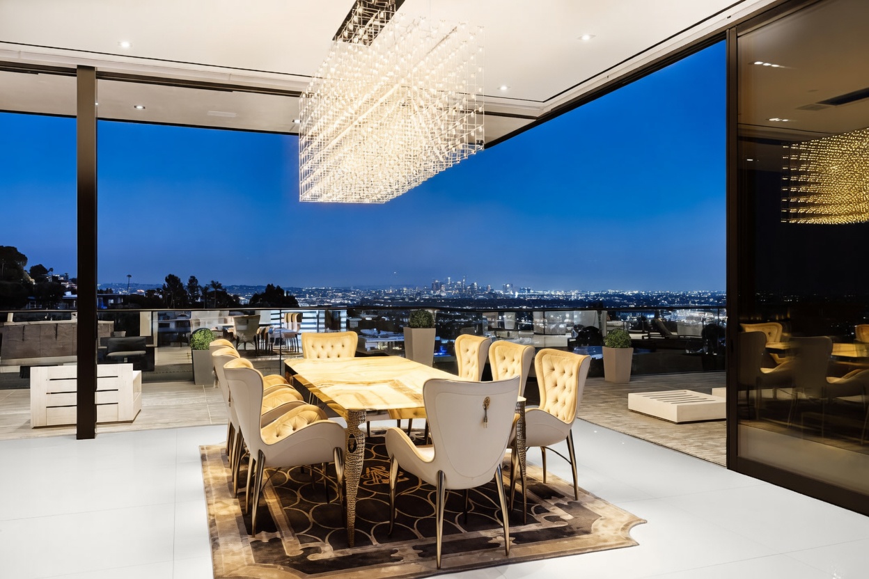 This luxurious dining room features an open-concept design that seamlessly transitions to an expansive outdoor terrace, offering a breathtaking panoramic view of the city skyline at dusk. The space is anchored by a sophisticated dining table surrounded by elegant, tufted-back chairs, all illuminated by a grand, multi-tiered crystal chandelier. The sleek, modern aesthetic is enhanced by floor-to-ceiling glass walls, creating a dramatic and high-end atmosphere perfect for sophisticated entertaining.
