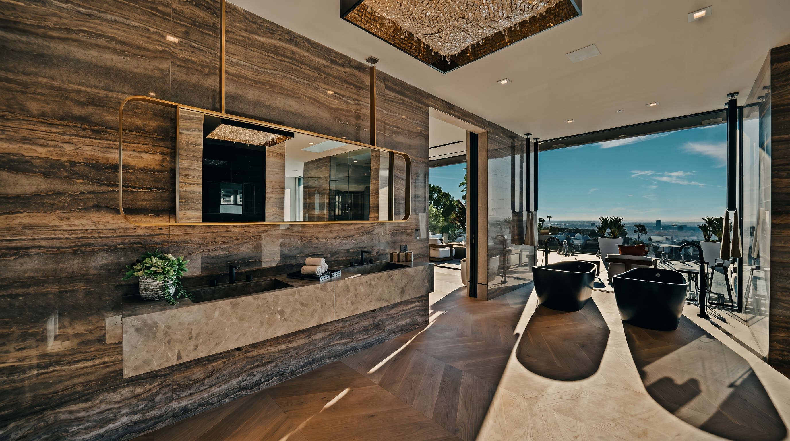 This luxurious primary bathroom features a striking combination of rich, veined stone walls and light herringbone wood flooring. The space is anchored by a long, floating stone vanity with dual sinks and a large, gold-framed mirror, complemented by two sleek black soaking tubs positioned near floor-to-ceiling windows that offer expansive views. A dramatic, crystal-encrusted chandelier hangs above, adding a touch of opulence to the modern, high-end design.