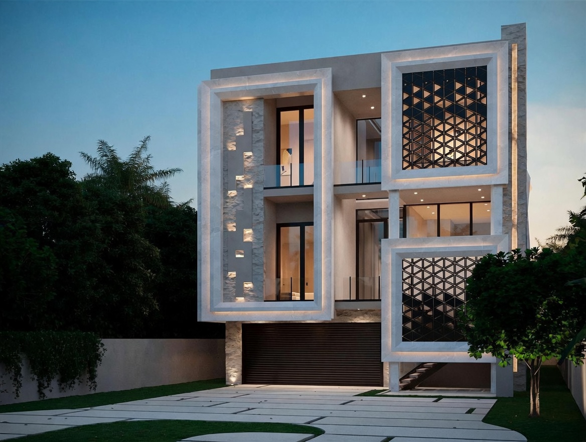 This modern three-story residence features a striking architectural design with geometric framing, stone-clad accents, and decorative metal screens. The front facade showcases large windows and glass-railed balconies, illuminated by integrated warm lighting that highlights the building's clean lines. A paved driveway leads to a dark, horizontal-slat garage door, set against a backdrop of lush trees and a twilight sky.