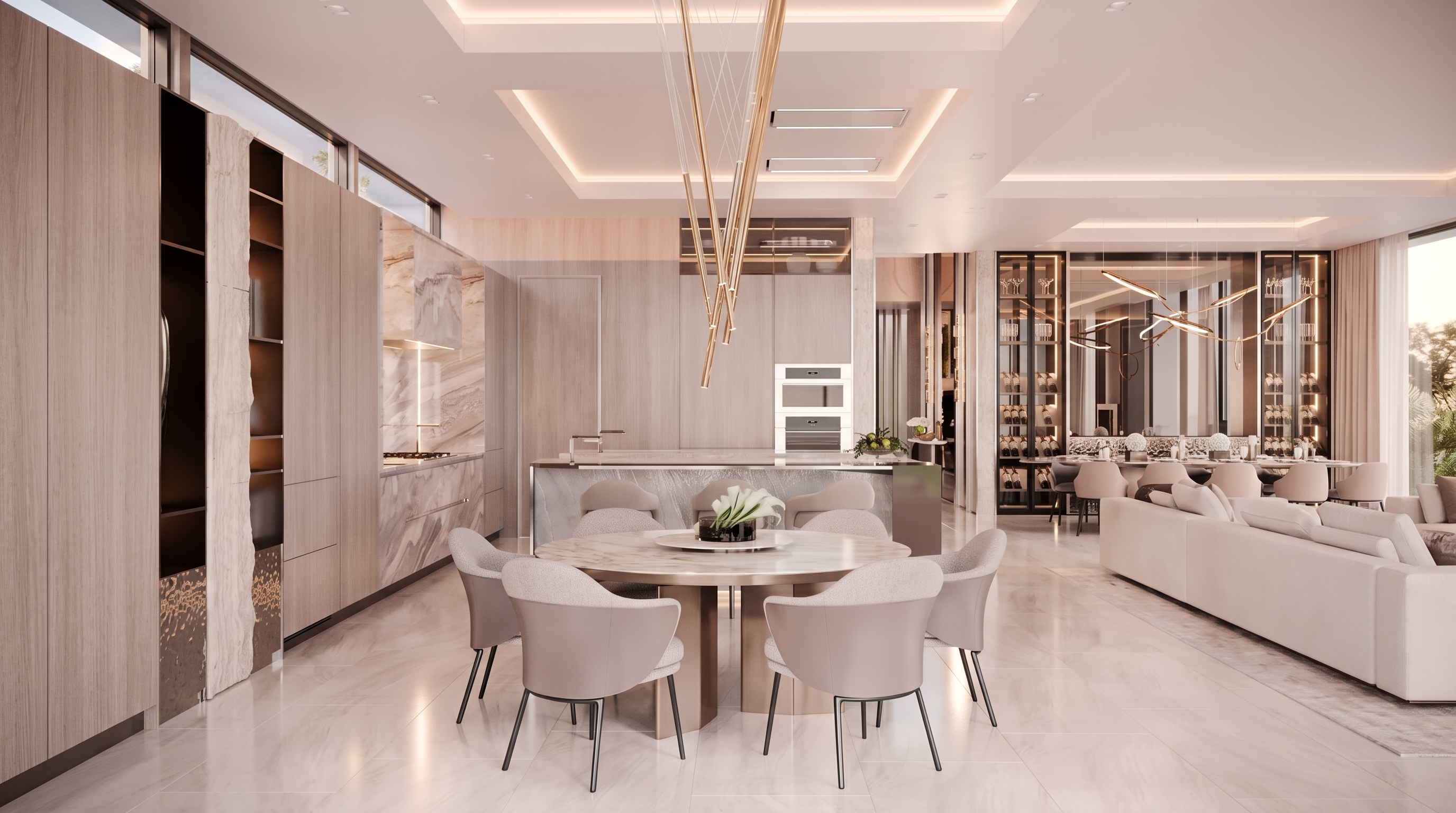 This sophisticated open-concept kitchen and dining area features a central circular dining table surrounded by modern upholstered chairs, positioned beneath a striking sculptural pendant light. The kitchen is equipped with sleek light-toned cabinetry, integrated appliances, and a large stone-topped island that serves as a focal point. The space is characterized by a neutral color palette, polished stone flooring, and recessed ceiling lighting, creating an elegant and cohesive atmosphere.
