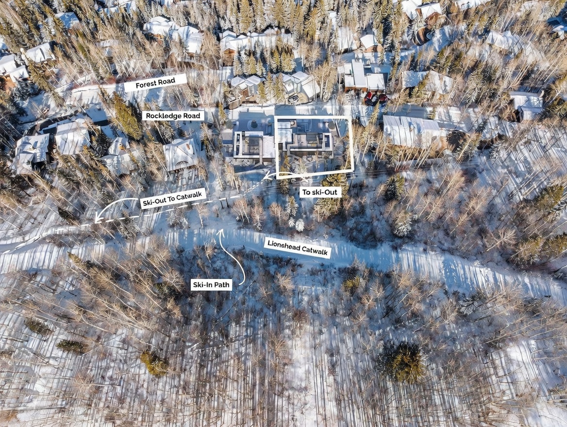 This aerial view captures a luxury mountain property nestled within a dense, snow-covered forest. The image highlights the home's strategic location with clear annotations indicating access to local roads and ski-in/ski-out paths, emphasizing its convenience for winter sports enthusiasts. The perspective provides a comprehensive look at the surrounding landscape and the property's integration into the wooded terrain.