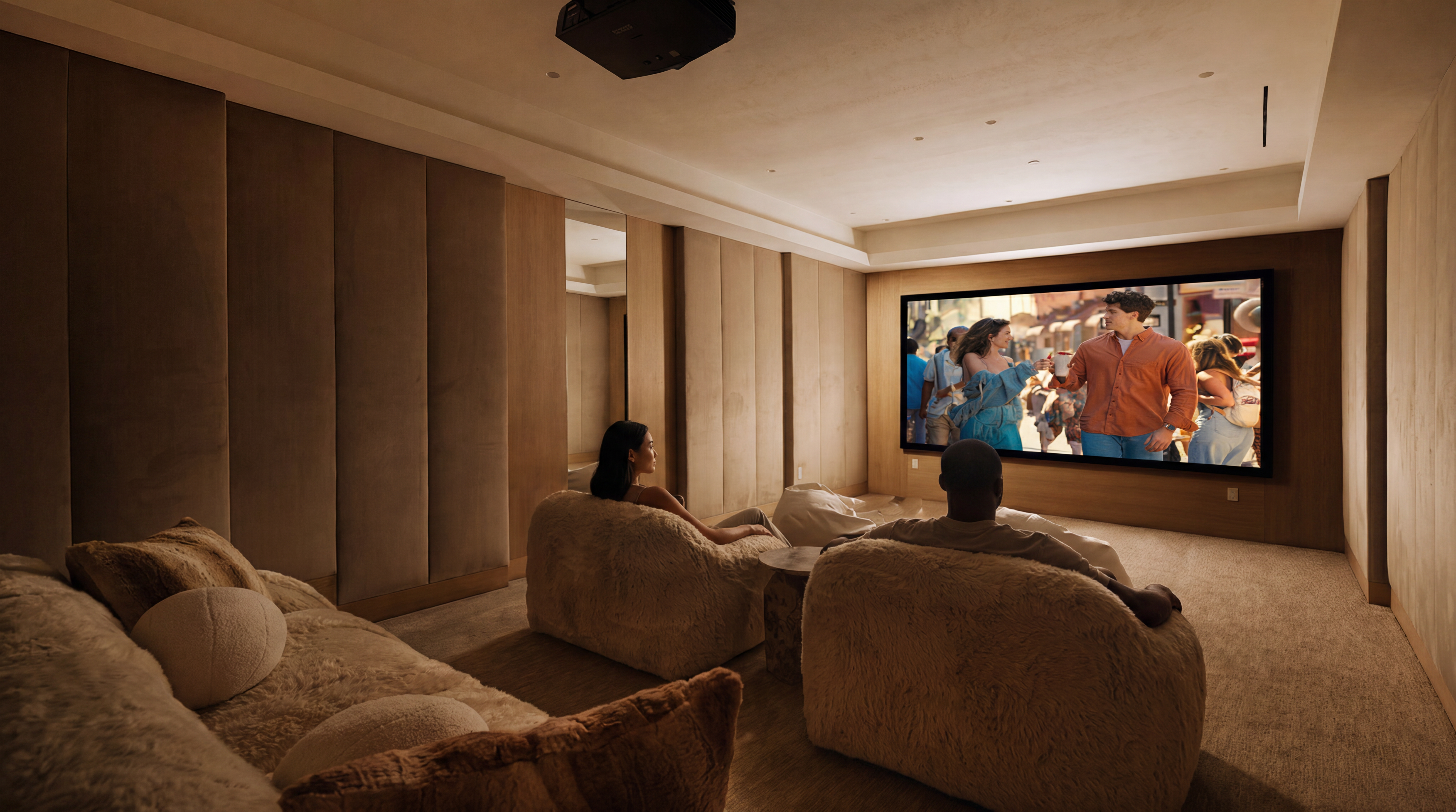 This luxurious home theater features plush, textured seating and a expansive screen, creating an immersive cinematic experience. The room is wrapped in sophisticated, fabric-paneled walls and neutral carpeting, exuding a warm and private atmosphere perfect for entertainment. With a projector mounted on the ceiling and optimized lighting, it serves as a high-end dedicated media space within the residence.