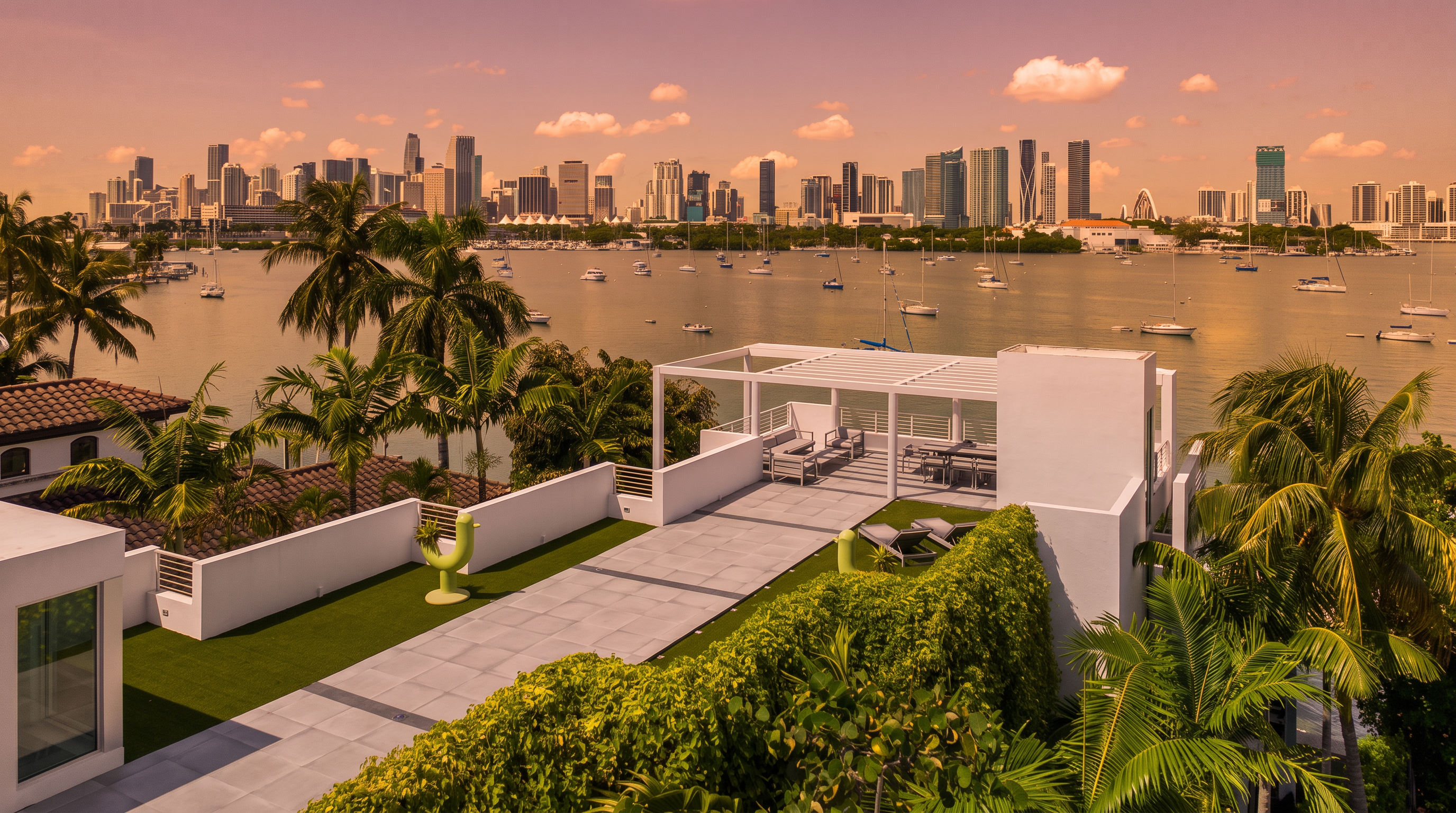 This elevated rooftop terrace offers a sophisticated outdoor living space with a modern pergola, comfortable lounge seating, and a dining area. The deck features light-toned stone pavers bordered by lush green hedges and artificial turf, creating a clean, contemporary aesthetic. The vantage point provides a sweeping, panoramic view of the bay and the distant city skyline, emphasizing the property's prime waterfront location.