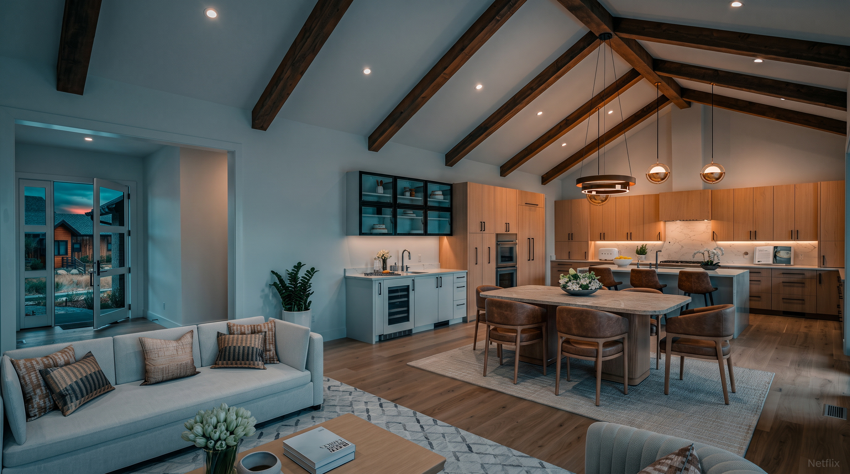 This spacious open-concept living area seamlessly integrates a sophisticated lounge space with a dining room and kitchen, all under a stunning vaulted ceiling with exposed wooden beams. The neutral color palette, light wood flooring, and soft textures create an inviting and airy atmosphere, perfect for modern living. Notable highlights include a sleek wet bar area, premium kitchen finishes, and easy flow to the outdoor space, reflecting high-end design and functionality.