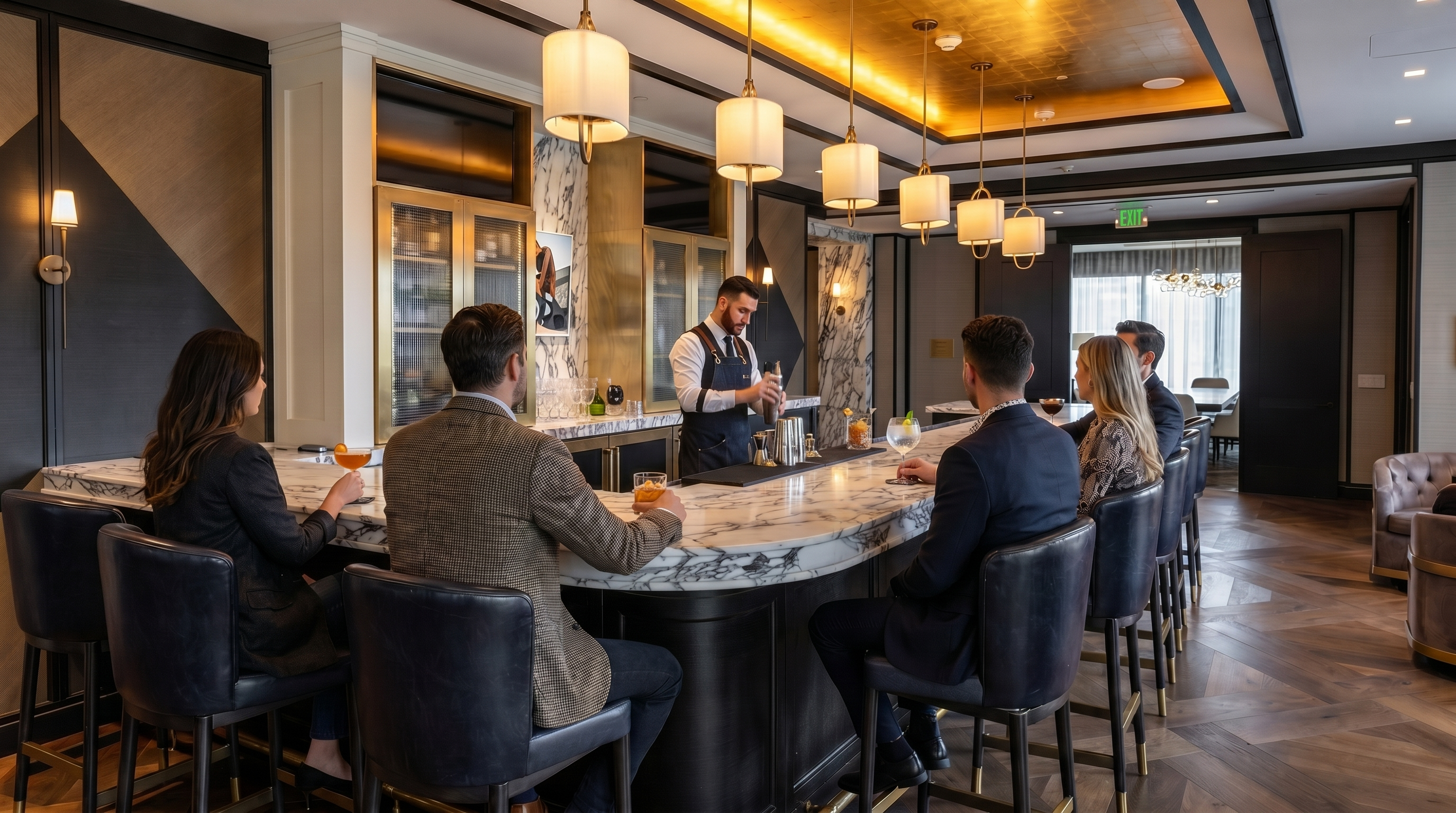 This sophisticated bar area features high-end finishes, including a stunning gold-leaf ceiling, dark wood flooring with a herringbone pattern, and a sleek marble-topped counter with navy leather stools. The opulent design creates an inviting atmosphere suitable for a luxury residential clubhouse or high-end lounge. Its elegant aesthetic is complemented by recessed and pendant lighting, providing a welcoming environment for social gatherings.
