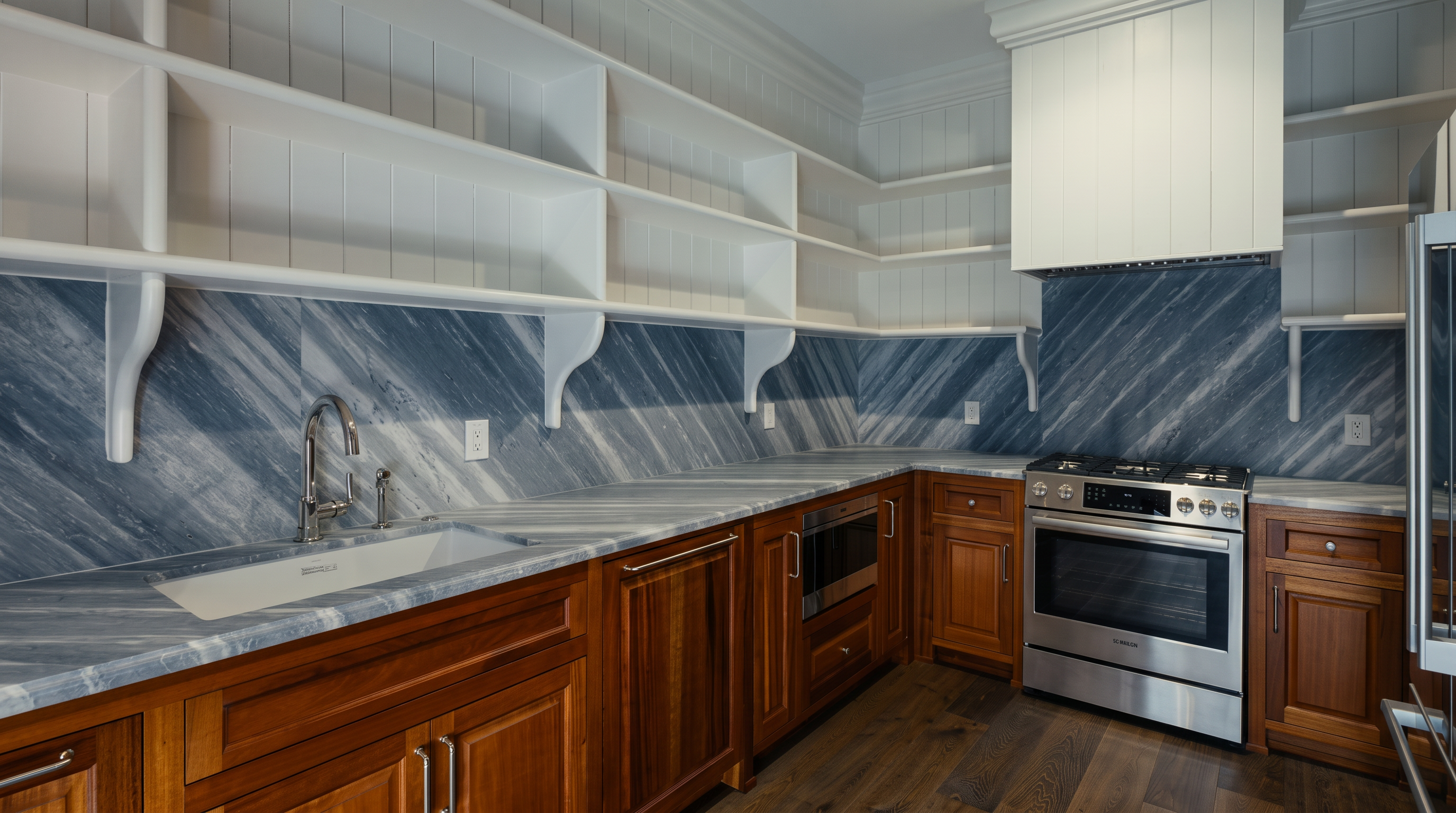This kitchen features warm-toned wood cabinetry paired with striking grey-veined stone countertops and a matching backsplash. The space is equipped with a stainless steel range, a built-in microwave, and an apron-front sink, all complemented by open white shelving that provides an airy, organized feel. The perspective is a wide-angle shot from the corner, showcasing the functional layout and the contrast between the natural wood tones and the cool-toned stone surfaces.