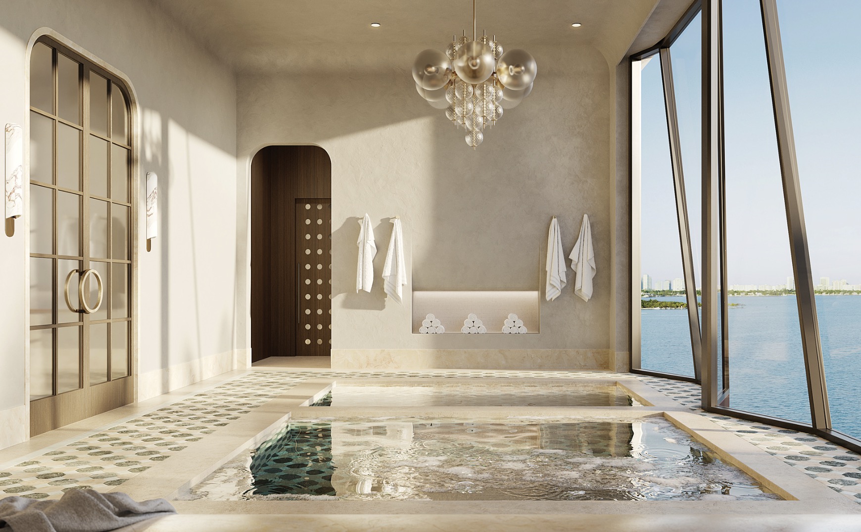 This luxurious primary bathroom features a unique indoor spa pool with patterned tile flooring that extends throughout the room. Natural light floods the space through large windows offering ocean views, while a modern chandelier hangs above. The design incorporates arched doorways and neutral tones, creating a serene and upscale atmosphere.