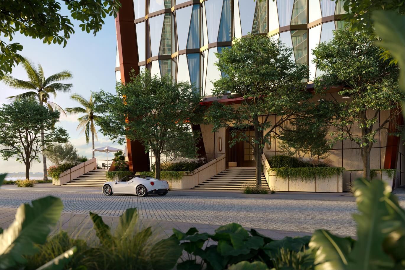 This image showcases the grand entryway of a modern building, featuring a striking architectural design with geometric glass panels and warm-toned accents. Lush greenery flanks the entrance steps, leading to a sophisticated doorway. A sleek white sports car is parked nearby, adding a touch of luxury and highlighting the upscale ambiance of the property.