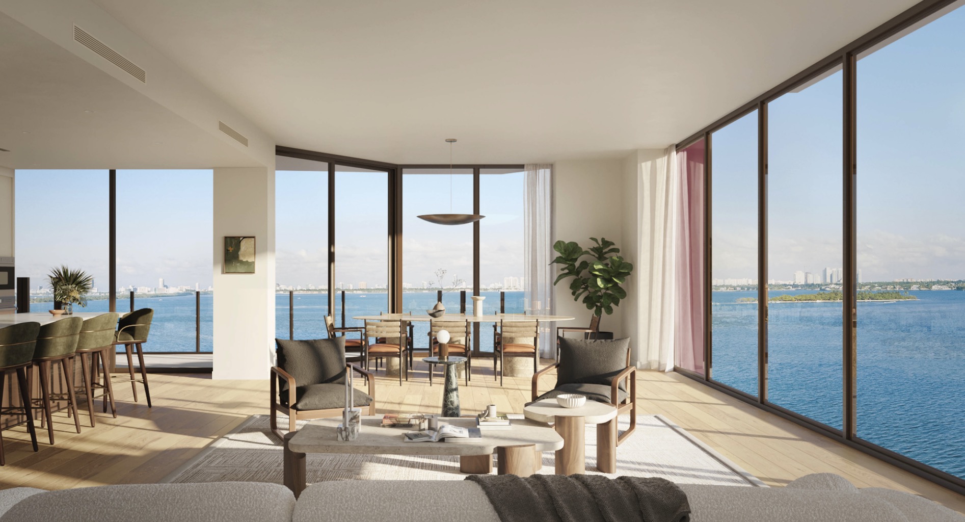 This is a bright and airy living space with floor-to-ceiling windows offering stunning water views. The open-concept design seamlessly integrates the living, dining, and kitchen areas, creating a spacious and inviting atmosphere. The interior features modern furnishings, including comfortable seating, a stylish dining table, and a sleek kitchen island, all complemented by natural light and a neutral color palette.