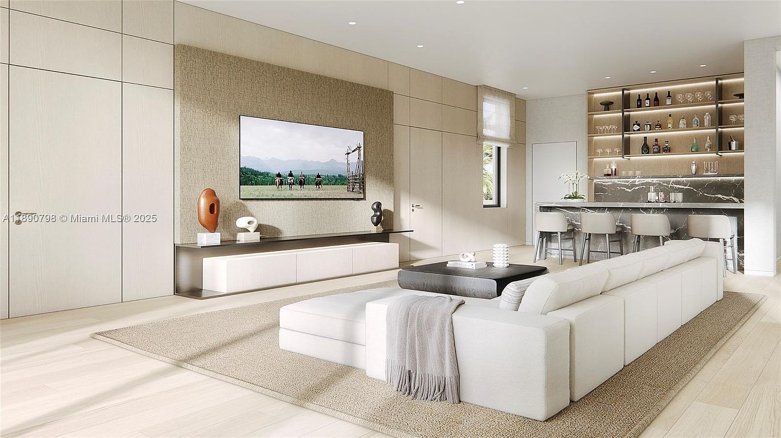 This is a modern living room featuring a large sectional sofa, a sleek entertainment center with a flat-screen TV, and a stylish bar area. The color palette is neutral, creating a serene and sophisticated atmosphere. The room is well-lit and appears spacious, making it an inviting space for relaxation and entertainment.