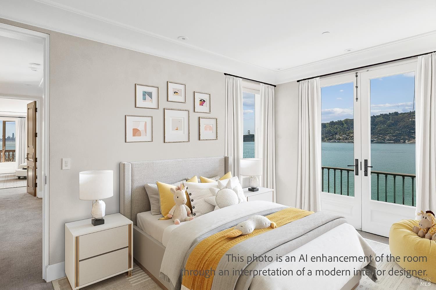 This bright and airy bedroom features a neutral color palette with soft yellow accents, centered around a plush bed adorned with decorative pillows and a stuffed animal. Large glass doors open onto a balcony, providing a stunning, unobstructed view of the water and distant hills. A gallery wall of framed art adds a personalized touch, while matching bedside tables with modern lamps complete the clean, contemporary aesthetic.