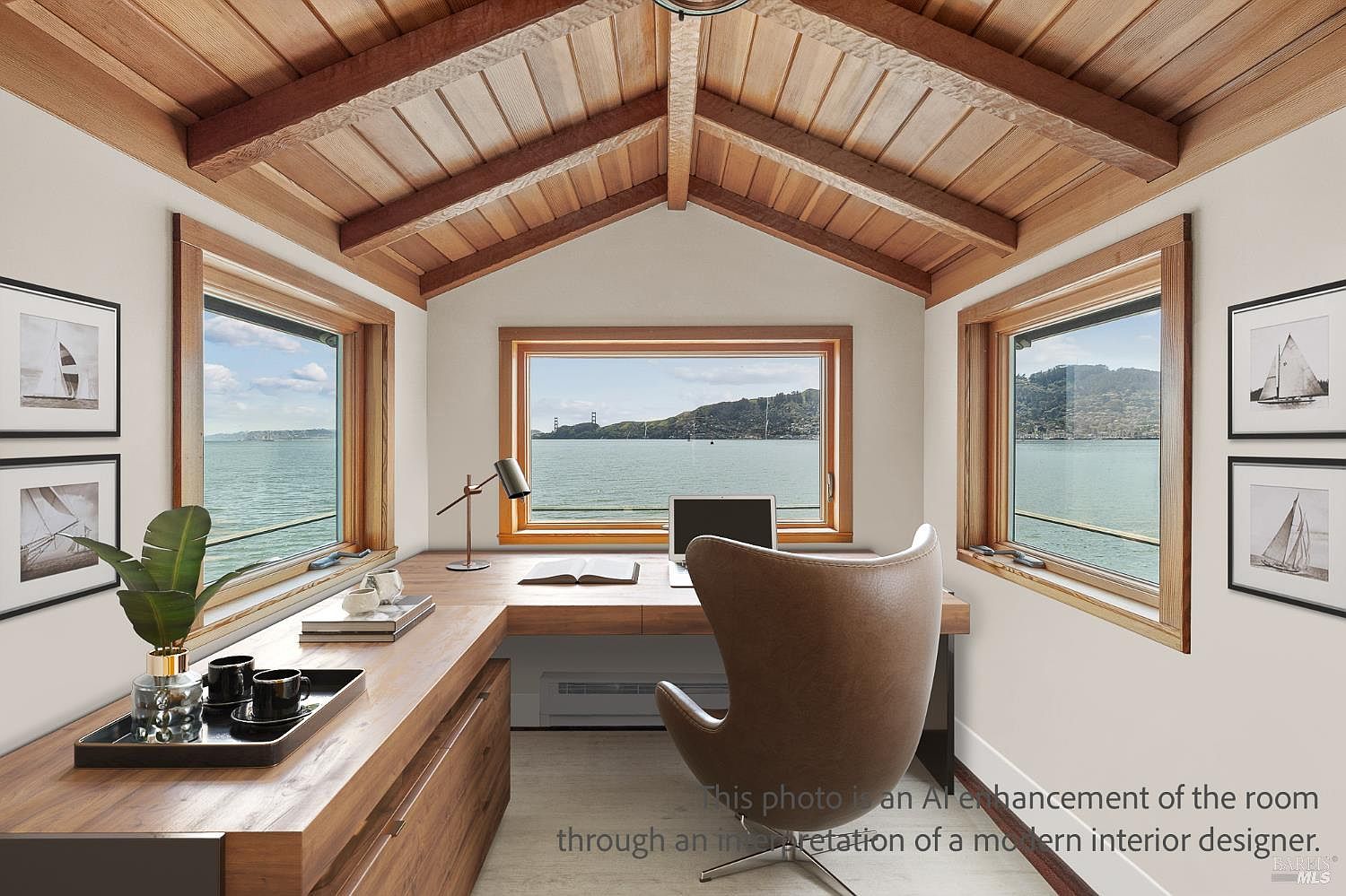 This home office features a large, L-shaped wooden desk positioned to take advantage of panoramic water views through three expansive windows. The room is characterized by a vaulted, exposed-beam wood ceiling that adds warmth and architectural interest to the space. A modern, curved leather chair faces the desk, creating a serene and focused workspace overlooking the bay.