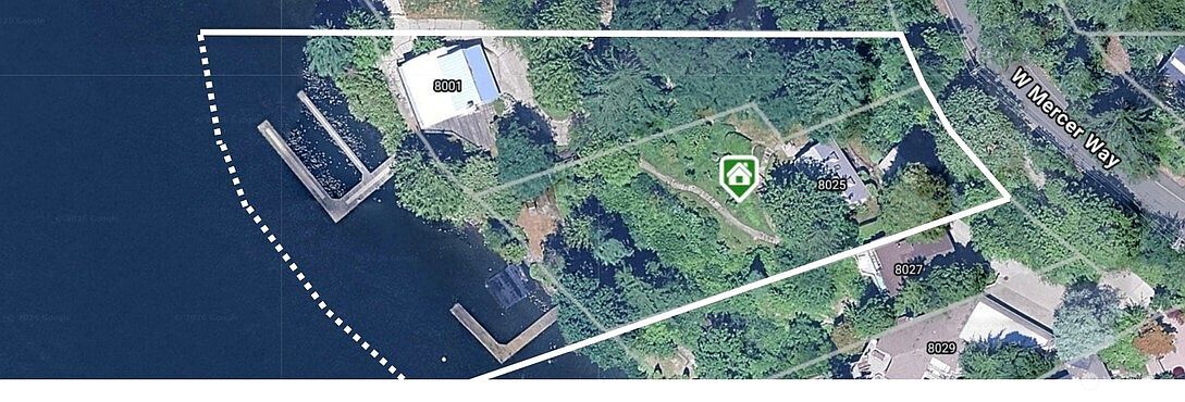 This aerial view captures a waterfront property on Mercer Island, highlighting its expansive lot, lush greenery, and direct lake access. The property features two distinct docks extending into the water and a main residence nestled among mature trees, with a clear property boundary outlined in white. The perspective provides a comprehensive look at the home's prime location, privacy, and outdoor recreational potential.