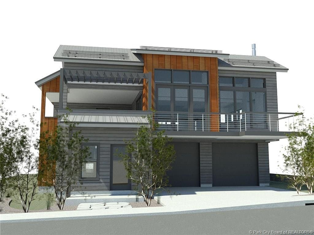 This is a front view of a modern two-story house with a gray and wood exterior. The house features a balcony with metal railings, large windows, and a two-car garage. The landscaping includes small trees and a well-maintained lawn, creating a clean and contemporary aesthetic.