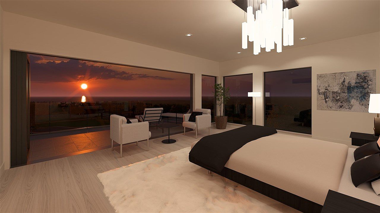 This is a luxurious primary bedroom featuring a modern design with a large bed, contemporary lighting fixture, and an abstract art piece. The room opens onto a balcony with outdoor seating, offering stunning sunset views. The interior is spacious and well-lit, creating a serene and upscale atmosphere.