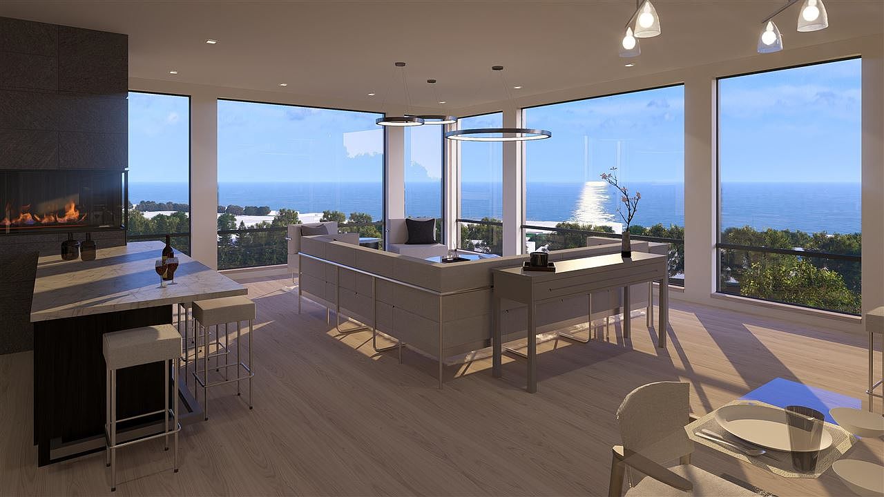 This is a bright and modern living room with floor-to-ceiling windows offering stunning ocean views. The room features a sleek, low-profile sofa, a contemporary fireplace, and a stylish dining area. The open floor plan and minimalist design create a luxurious and inviting atmosphere.
