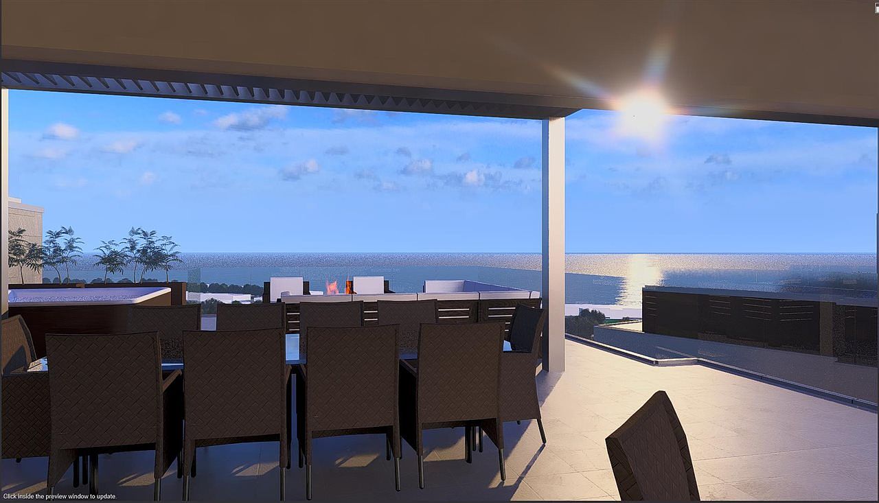 This image showcases a luxurious outdoor patio or balcony area, perfect for entertaining or relaxing. The space features a dining set with modern chairs, offering a comfortable spot to enjoy meals with an ocean view. The design emphasizes open-air living, with a clear view of the ocean and sky, creating a serene and upscale ambiance.