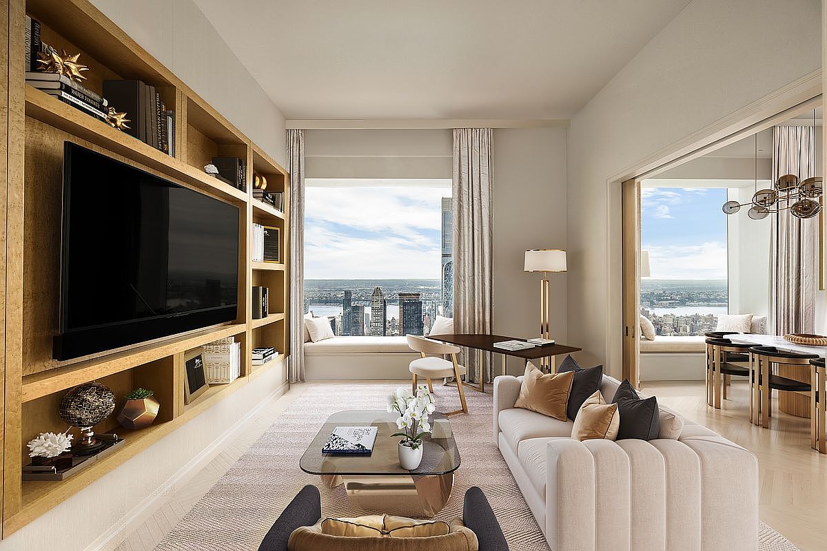 This is a luxurious living room featuring a built-in shelving unit with a large television, a comfortable sofa with decorative pillows, and a glass coffee table. The room offers stunning city views through a large window, complemented by elegant curtains and a cozy window seat. The overall design exudes sophistication and comfort, perfect for modern living.