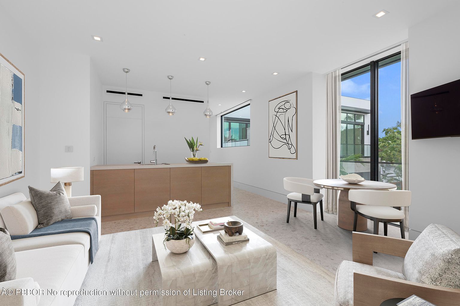 This is a bright and airy living room featuring a modern design with clean lines and neutral colors. The room includes a comfortable white sofa, a unique coffee table, and a dining area with stylish chairs. Large windows provide ample natural light and a view of the outdoors, enhancing the open and inviting atmosphere.