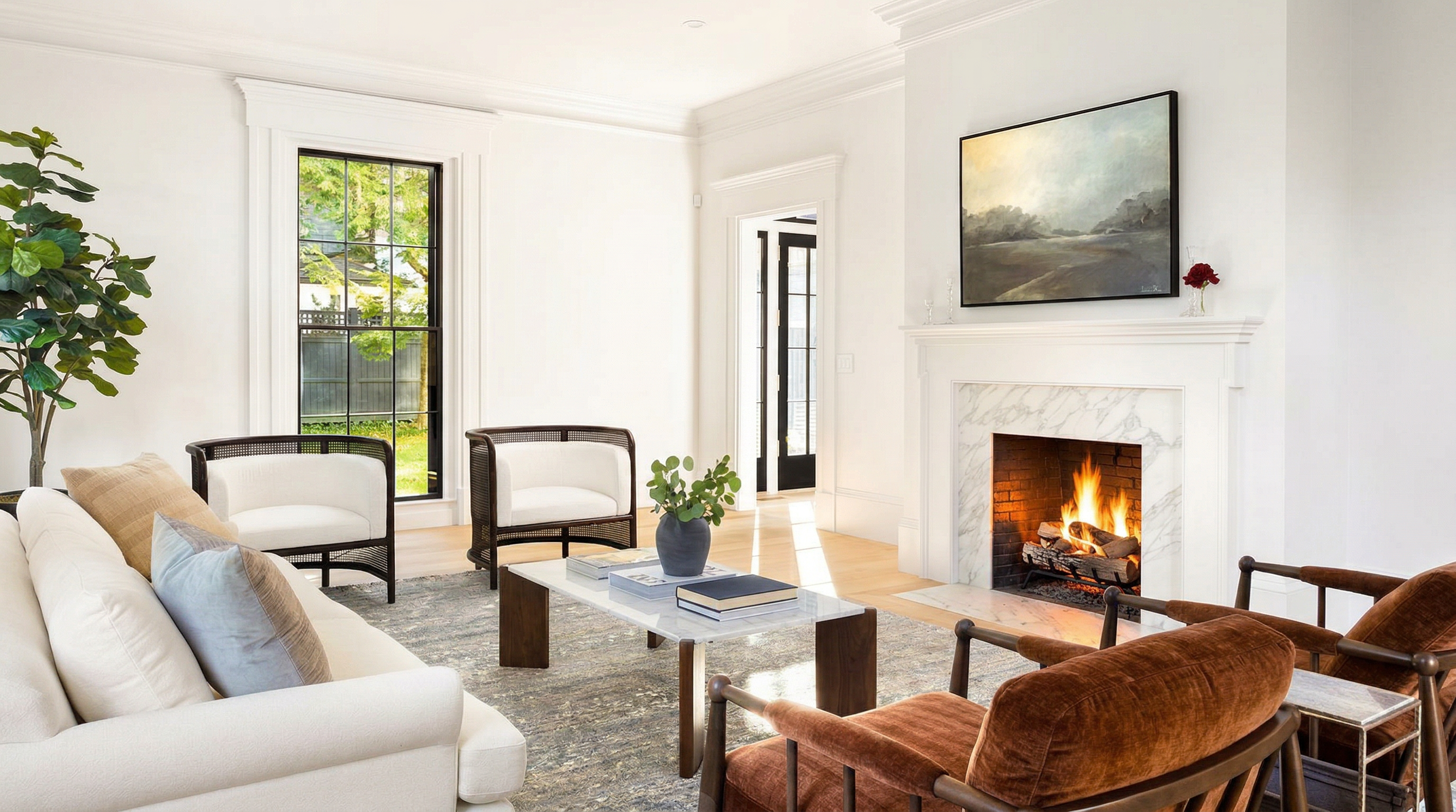 This elegant living room features a sophisticated blend of modern and classic design, anchored by a marble-surround fireplace and a large landscape painting. The space is furnished with a plush white sofa, two rich brown velvet armchairs, and two cane-back accent chairs, all arranged around a sleek marble-topped coffee table on a textured area rug. Large windows with black frames allow natural light to flood the room, creating an airy and inviting atmosphere perfect for high-end residential living.