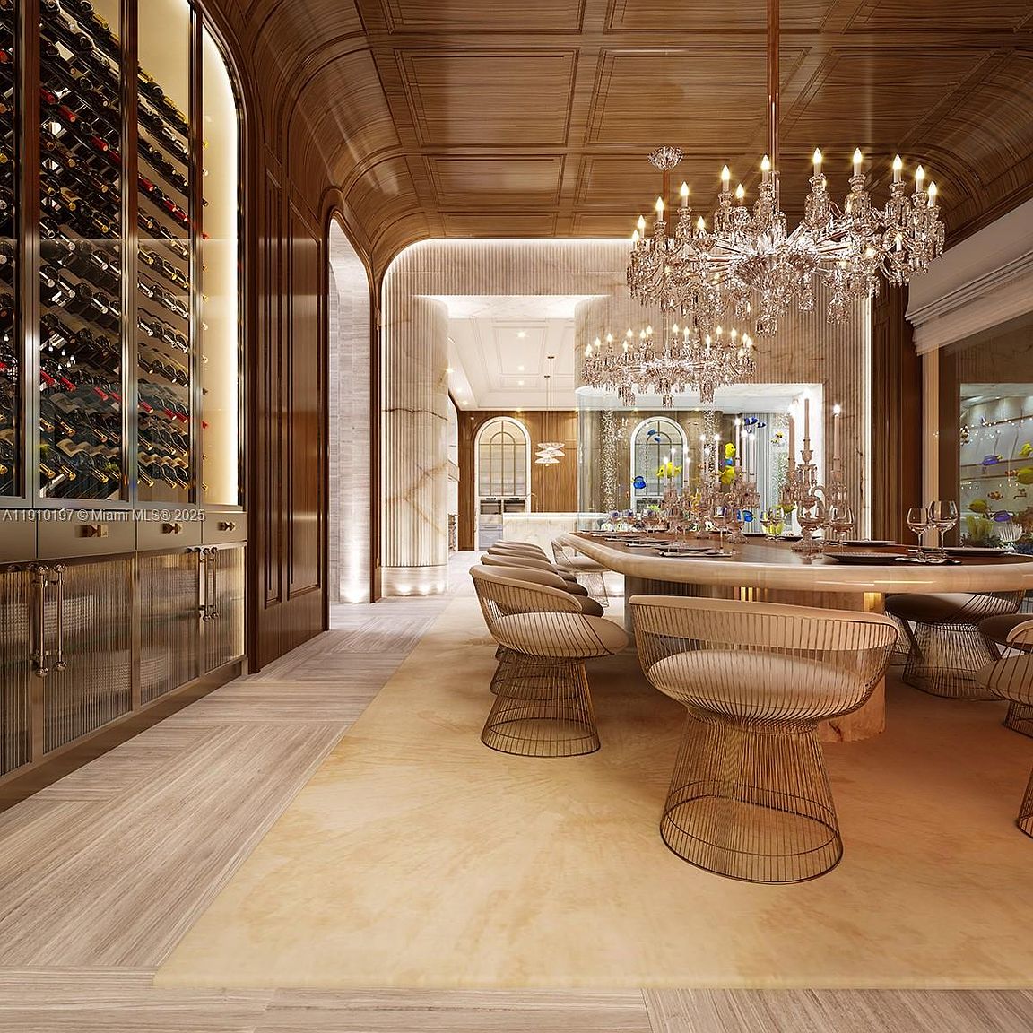 This is an elegant dining room featuring a large, round dining table with seating for several people. The room is illuminated by two ornate chandeliers, and a wine cellar is visible on the left. The overall style is luxurious and sophisticated, with wood paneling and a neutral color palette.