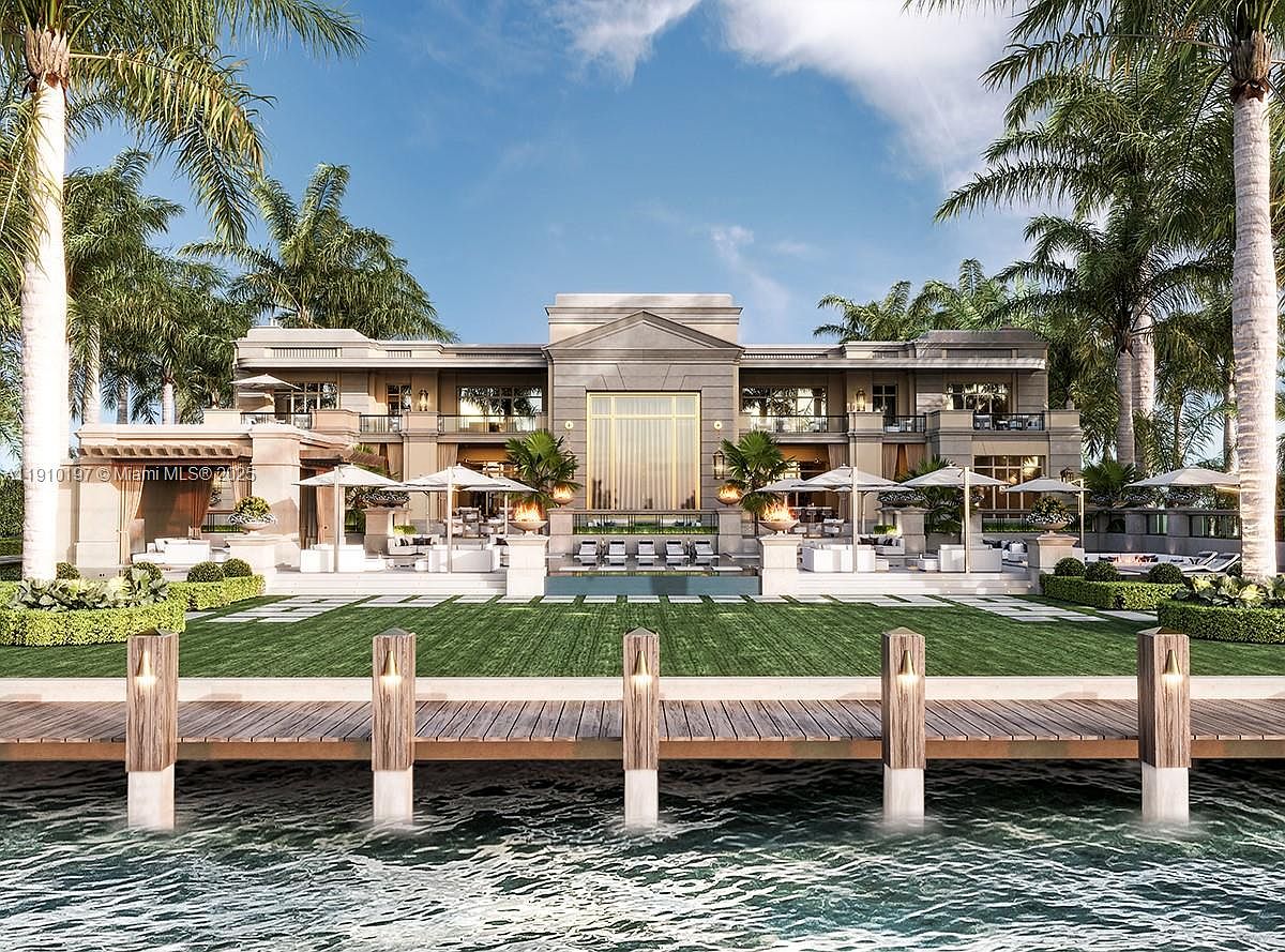 This image showcases the rear exterior of a luxurious waterfront property. The architectural style is modern and grand, featuring a large building with multiple windows and balconies, a pristine lawn, a swimming pool, and a private dock extending into the water. Palm trees frame the scene, enhancing the tropical ambiance.