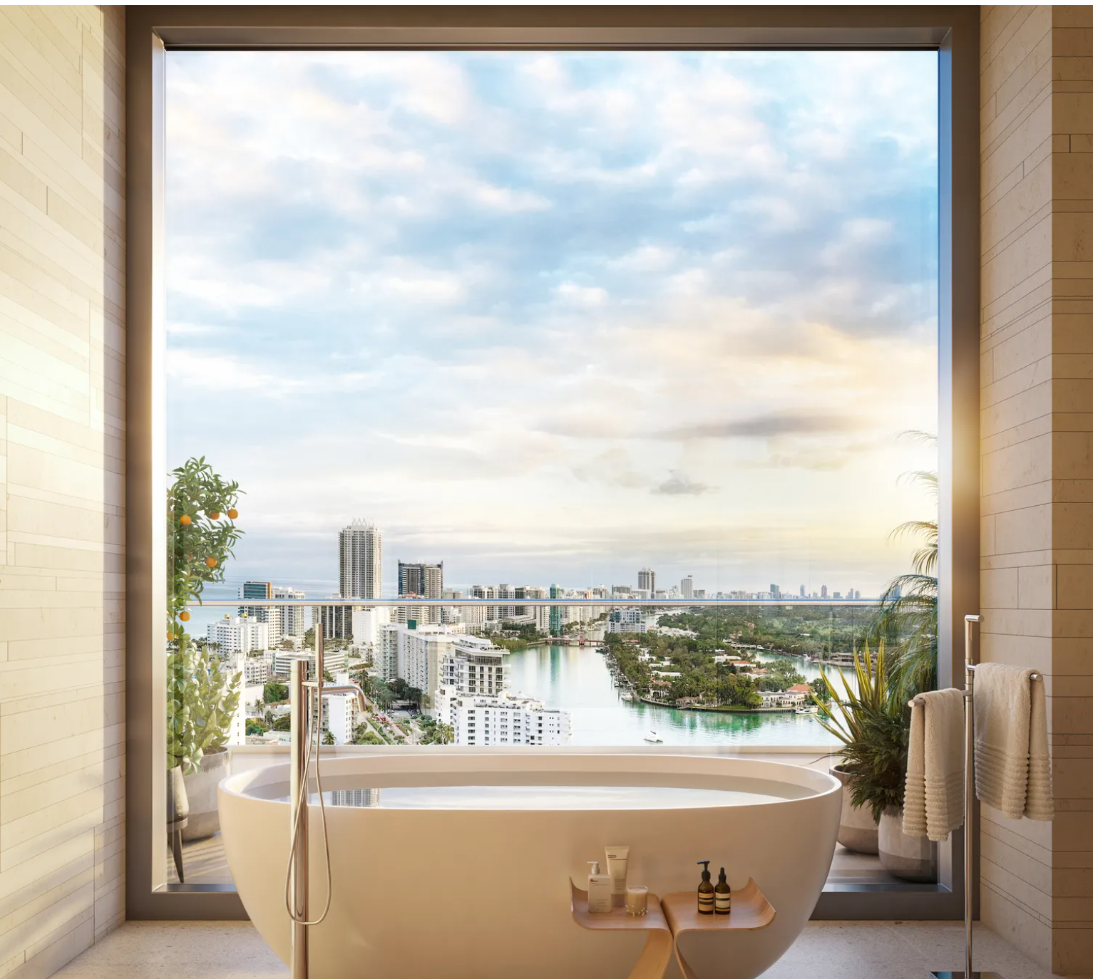 This is a luxurious primary bathroom featuring a freestanding soaking tub positioned in front of a large picture window with a city view. The neutral color palette and upscale fixtures contribute to a serene and spa-like atmosphere. The space also incorporates greenery, adding a touch of nature to the modern design.