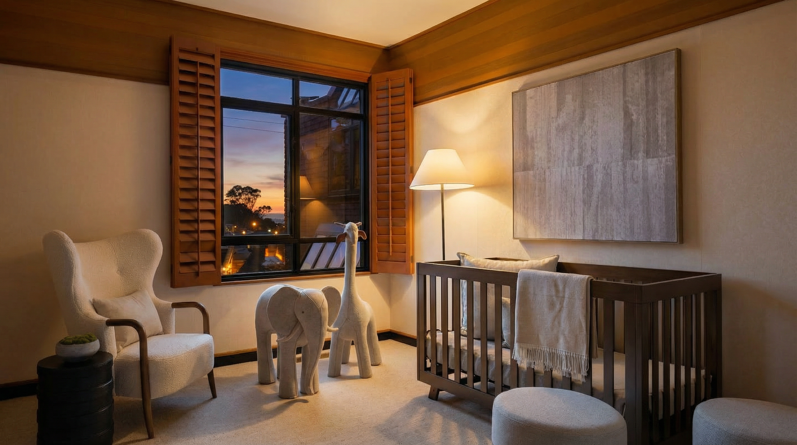 This is a cozy and inviting nursery featuring a neutral color palette. A comfortable armchair sits beside a dark wood side table, while a crib with a soft blanket and pillows is positioned near a window with wooden shutters. Decorative animal figures add a playful touch to the room, creating a serene and stylish space.