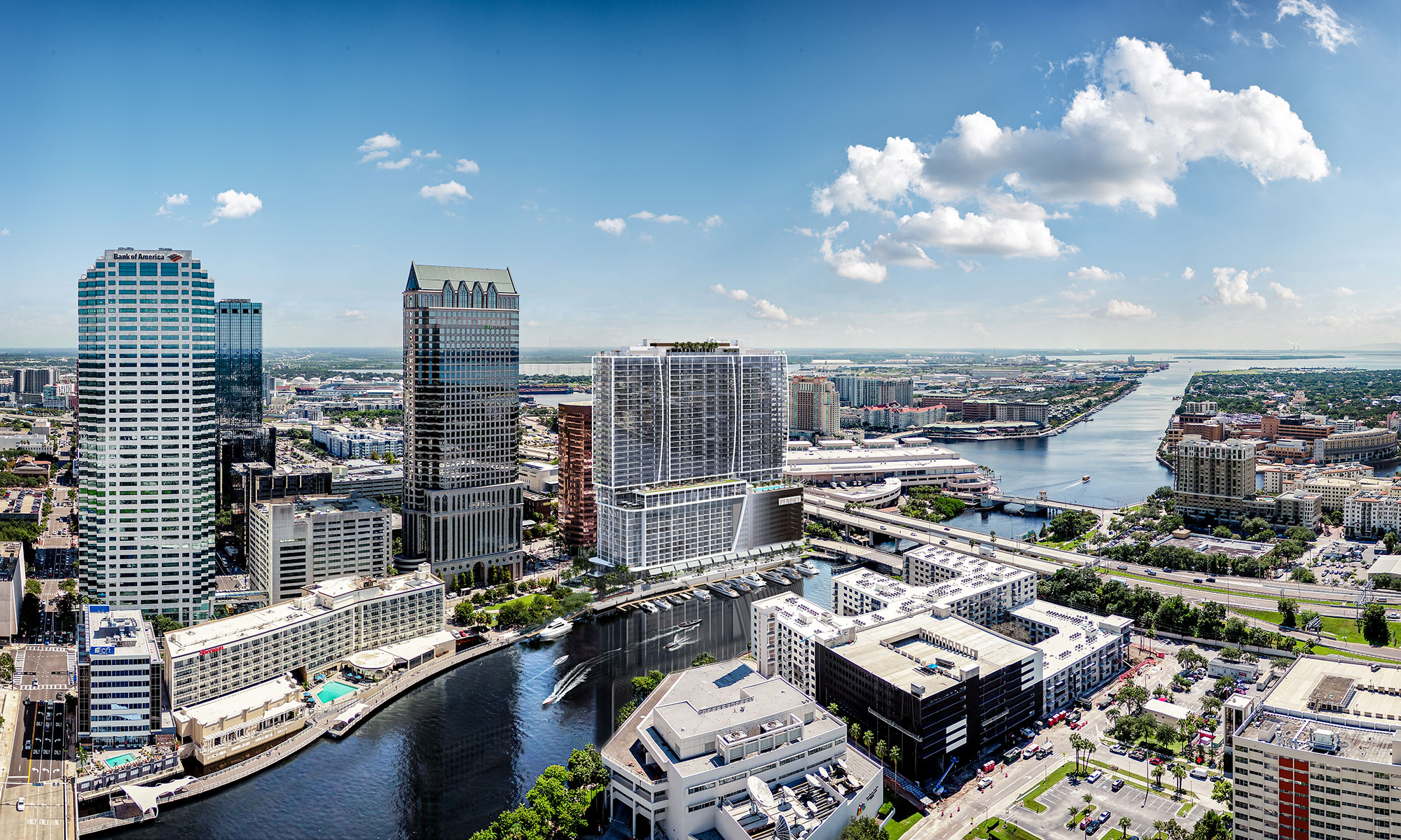 This aerial view showcases a vibrant cityscape with modern architecture, including prominent skyscrapers like Bank of America Plaza, and a scenic river winding through the urban landscape. The image captures a mix of commercial and residential buildings, with lush greenery interspersed, creating an appealing and dynamic urban environment. The clear blue sky and scattered clouds enhance the overall aesthetic, making it an attractive location for potential residents or businesses.