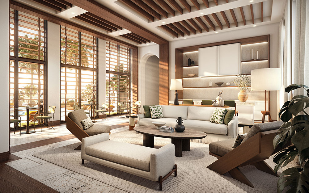 This is a bright and airy living room featuring large windows with louvered shutters that let in ample natural light. The room is furnished with a neutral-toned sofa, a wooden coffee table, and stylish armchairs, creating a comfortable and inviting atmosphere. The open-concept design flows seamlessly into the kitchen area, enhancing the sense of spaciousness.