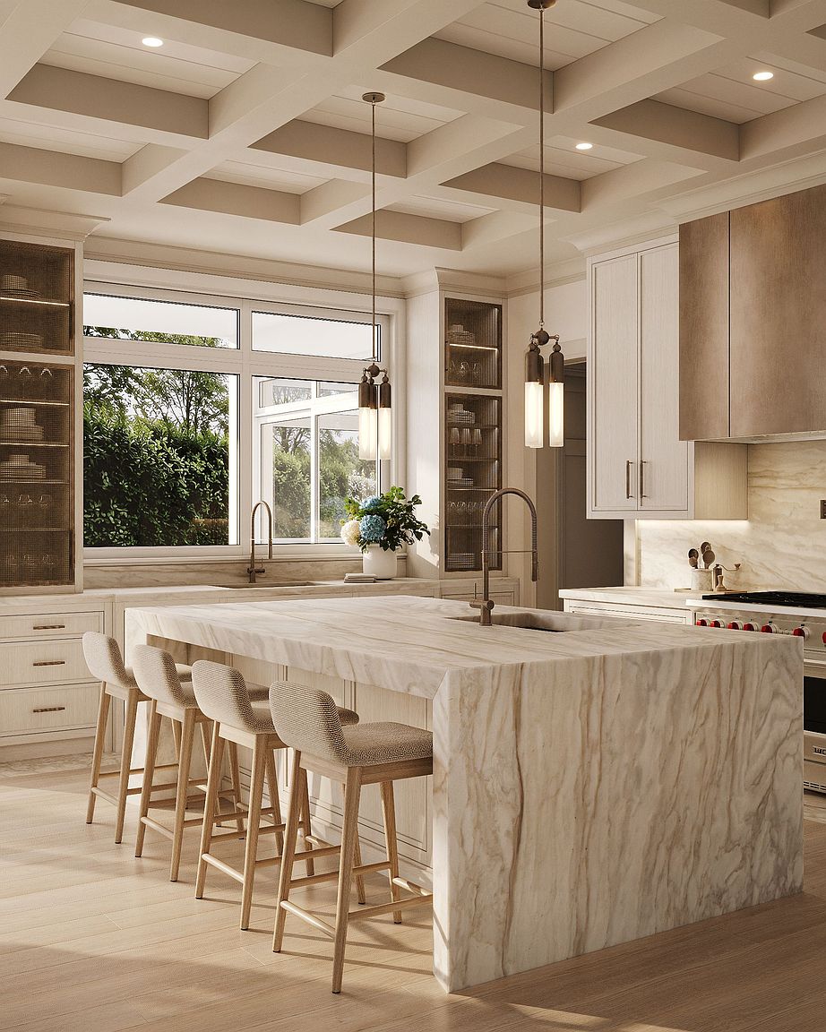 This sophisticated kitchen features a large central island with a waterfall-edge stone countertop and four upholstered bar stools. The space is defined by light-toned cabinetry, a coffered ceiling, and two elegant pendant lights hanging over the island. Large windows provide a bright view of the outdoors, while the overall aesthetic is clean, neutral, and high-end.