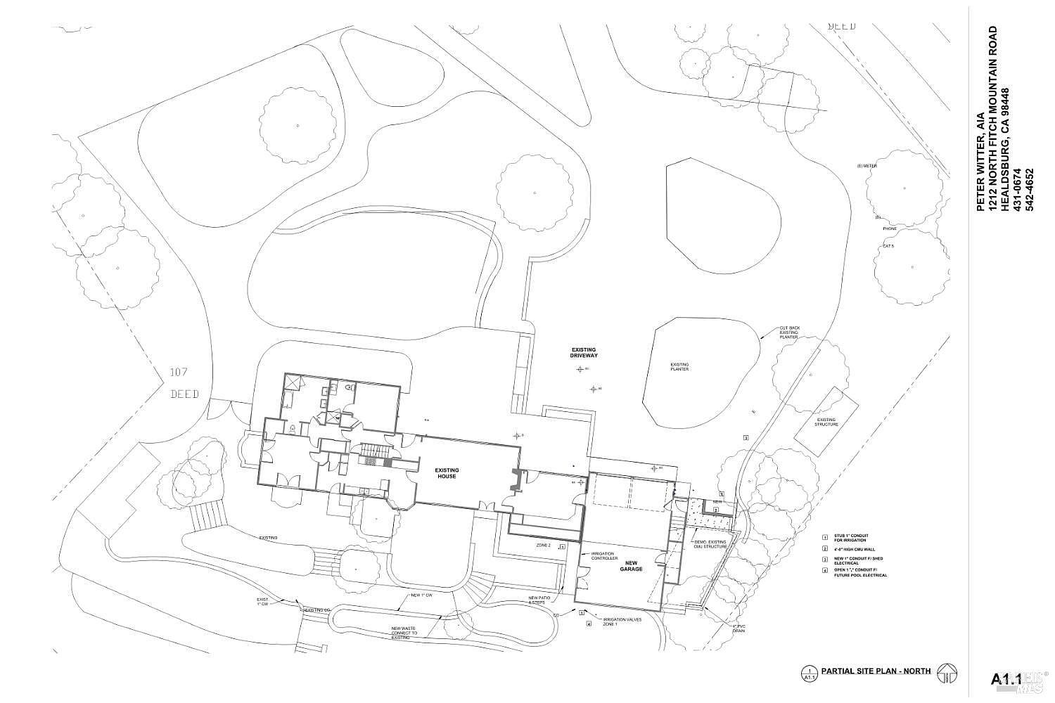 This image is a detailed architectural site plan for a residential property, illustrating the layout of an existing house, a new garage, and surrounding landscape features. The technical drawing includes labels for various site elements such as driveways, planters, irrigation zones, and utility conduits. It provides a top-down, technical perspective of the property's footprint and planned site improvements.
