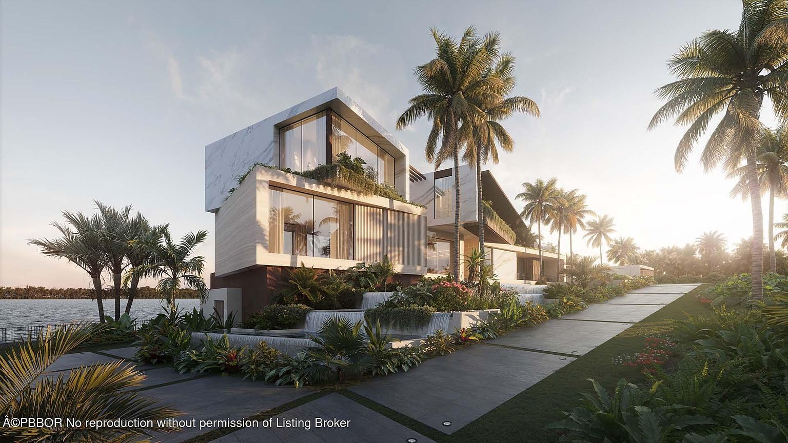 This image showcases the front exterior of a modern luxury home with a multi-tiered design, featuring a combination of marble and wood-like finishes. Lush landscaping surrounds the property, including palm trees and various plants, creating a tropical oasis. A paved driveway leads up to the house, and a body of water is visible in the background, suggesting a waterfront location.