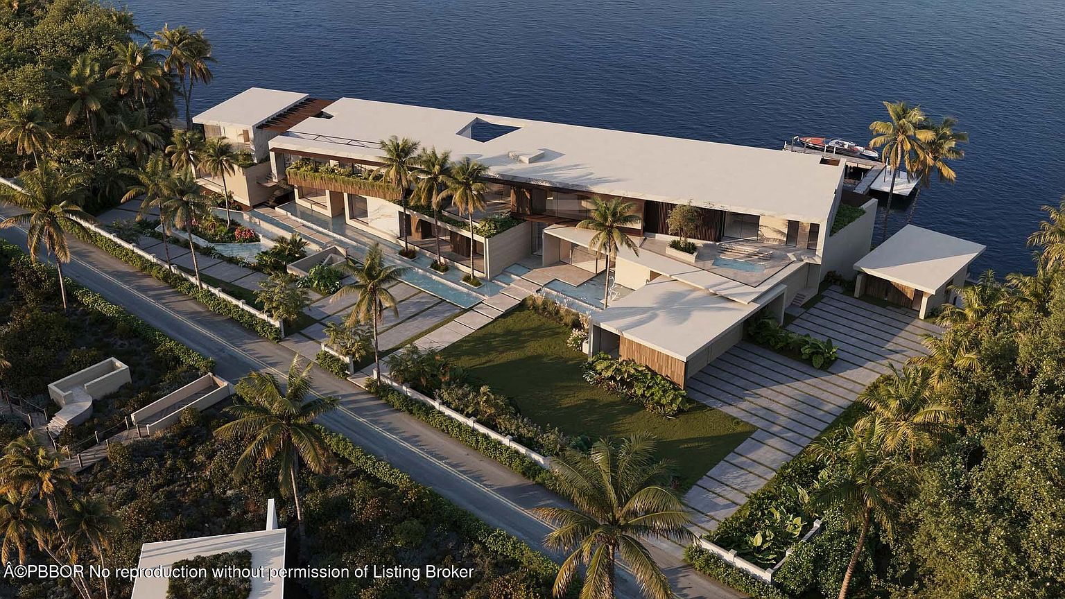 This aerial view showcases a luxurious waterfront property with a modern architectural design. The house features a flat roof, large windows, and multiple outdoor living spaces, including a pool and a boat dock. Lush landscaping with palm trees surrounds the property, enhancing its appeal and privacy.