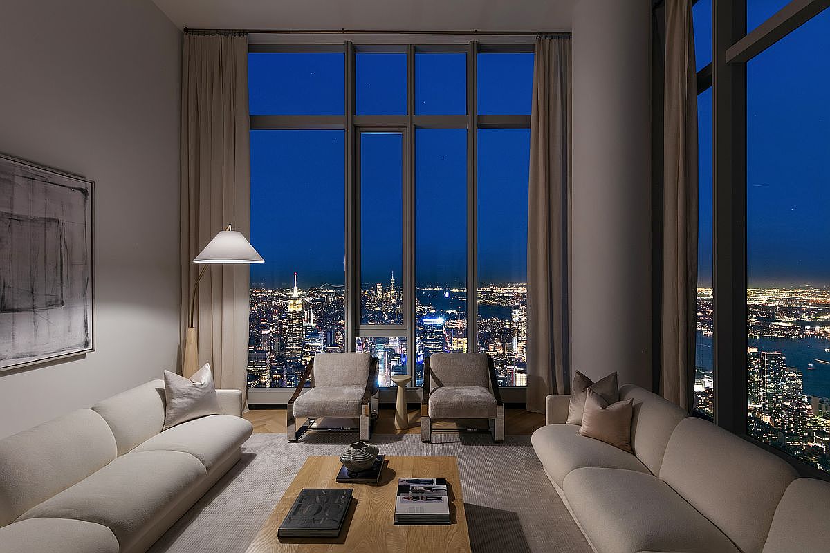 This sophisticated, high-rise living room features a symmetrical layout with two plush, cream-colored sofas facing each other across a minimalist wooden coffee table. Floor-to-ceiling windows provide a breathtaking, panoramic night view of the illuminated city skyline, creating a dramatic and luxurious atmosphere. The space is accented by a modern floor lamp, neutral-toned armchairs, and subtle wall art, emphasizing a refined, contemporary aesthetic.