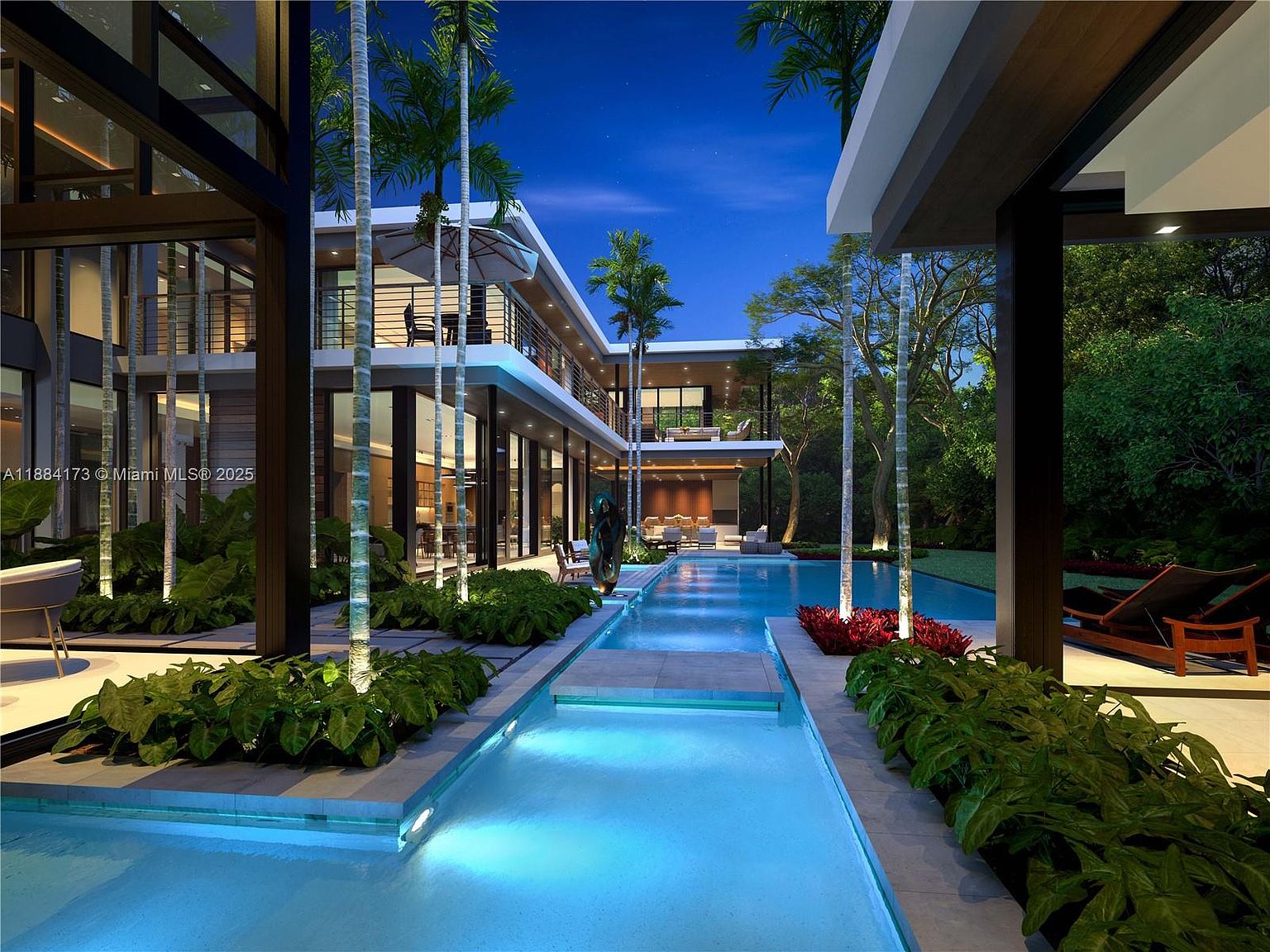 This is a stunning rear exterior view of a modern luxury home at night, showcasing a long, illuminated pool and spa area. The architecture features clean lines, large glass windows, and balconies, blending indoor and outdoor living. Lush landscaping and strategically placed lighting enhance the ambiance, creating an inviting and sophisticated atmosphere.