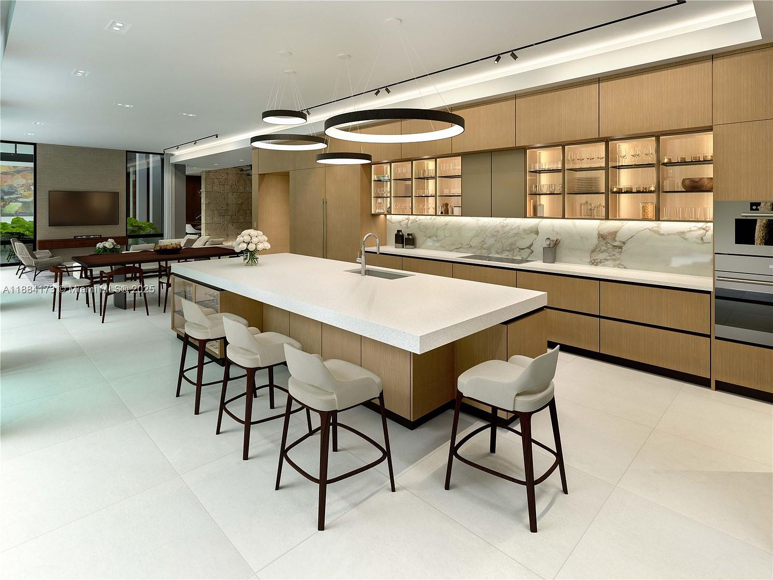 This is a modern, open-concept kitchen featuring a large island with seating, light wood cabinetry, and a marble backsplash. The kitchen is well-lit with recessed lighting and pendant fixtures, creating a bright and inviting atmosphere. The space flows seamlessly into a dining area, making it ideal for entertaining.