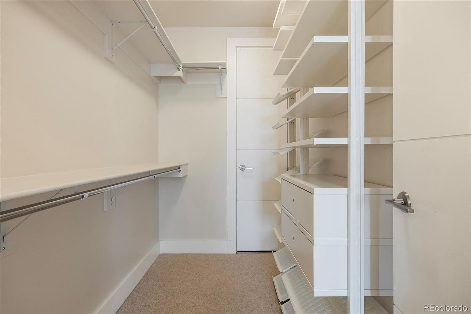 This is a well-organized walk-in closet featuring a combination of shelving, drawers, and hanging rods. The closet is painted in a neutral color, creating a bright and airy feel. The design maximizes storage space, making it an attractive feature for potential buyers.