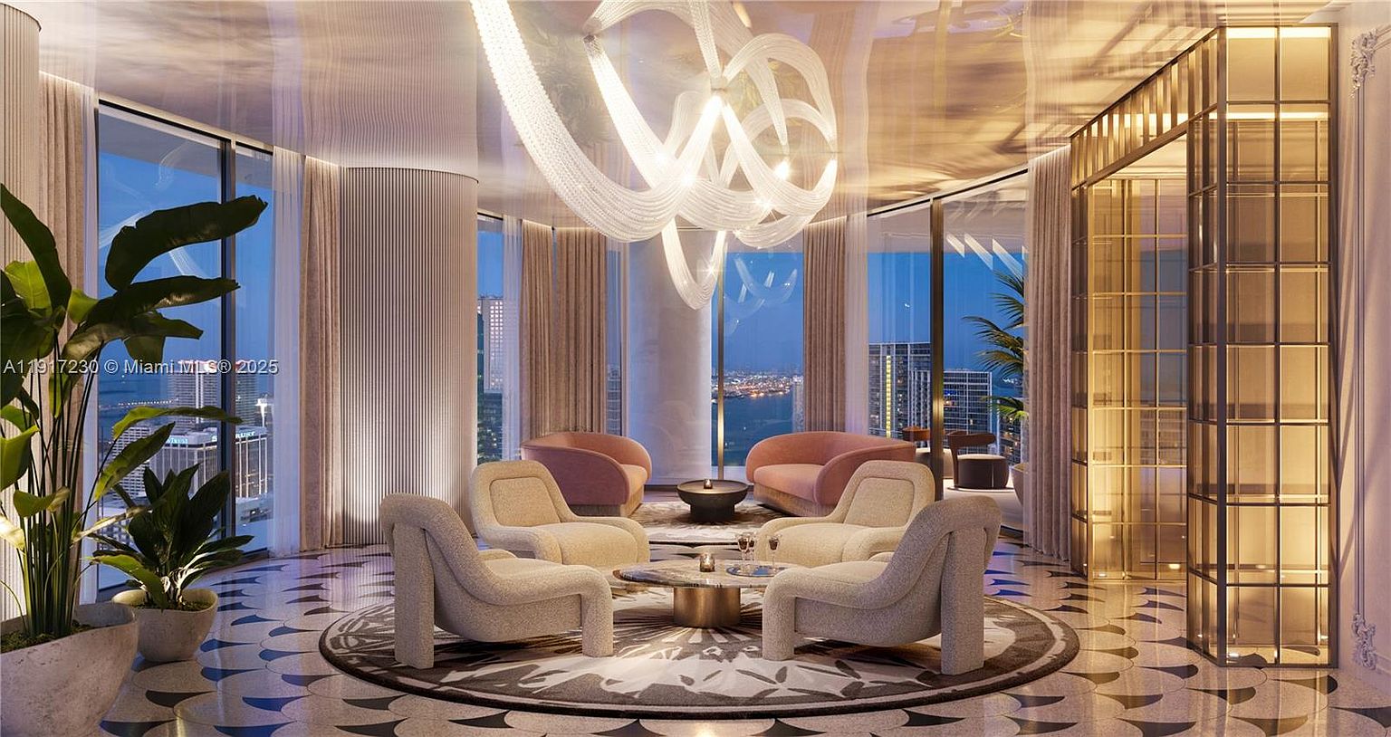This sophisticated lounge area features a circular seating arrangement with plush, light-toned armchairs and soft pink accent chairs centered around a round stone-topped table. The space is defined by a striking, sculptural chandelier suspended from a reflective ceiling, while expansive floor-to-ceiling windows offer panoramic city and water views. The room is anchored by a patterned tile floor, creating a luxurious and modern atmosphere suitable for high-end entertaining.