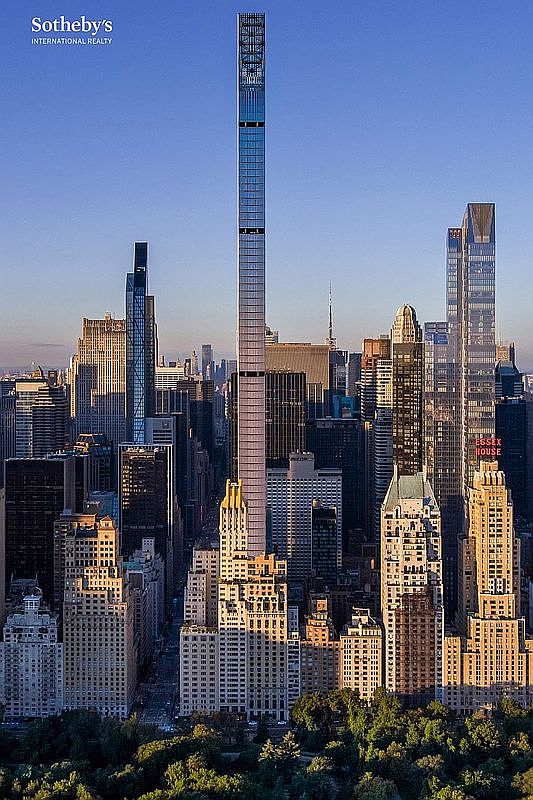 This striking aerial view captures the iconic New York City skyline, dominated by the exceptionally slender 432 Park Avenue skyscraper rising prominently above the surrounding urban landscape. The perspective looks down over the lush greenery of Central Park, contrasting the natural park space with the dense, historic, and modern architectural fabric of Manhattan. The golden hour lighting casts long shadows, emphasizing the verticality of the buildings and the dense, prestigious character of the neighborhood.