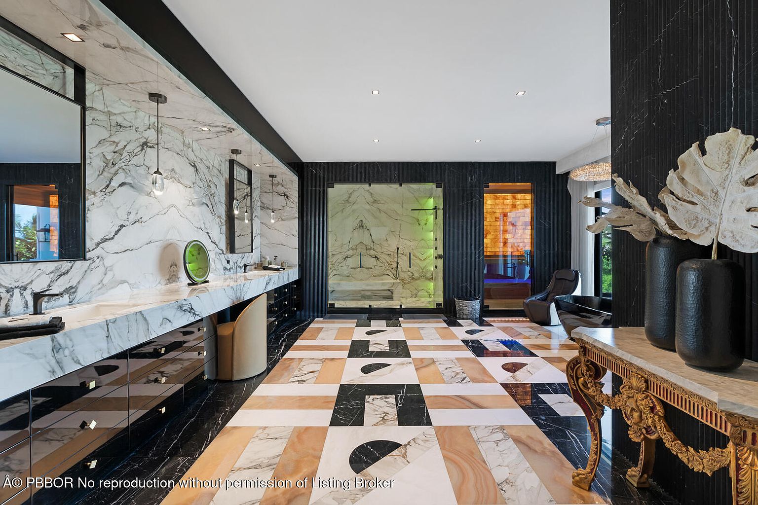 This is a luxurious primary bathroom featuring a double vanity with marble countertops and backsplash, complemented by modern fixtures and lighting. The floor is a striking geometric pattern of marble tiles, leading to a glass-enclosed shower and a separate sauna area. The overall impression is one of opulence and contemporary design.