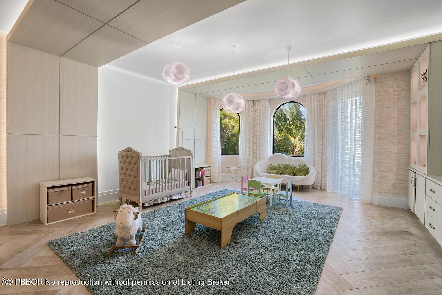 This is a charming children's bedroom featuring a neutral color palette with a light blue rug. The room includes a crib, a rocking sheep, a play table with chairs, and a comfortable sofa with green pillows. Large arched windows with sheer curtains provide natural light, and the overall design creates a serene and playful atmosphere.
