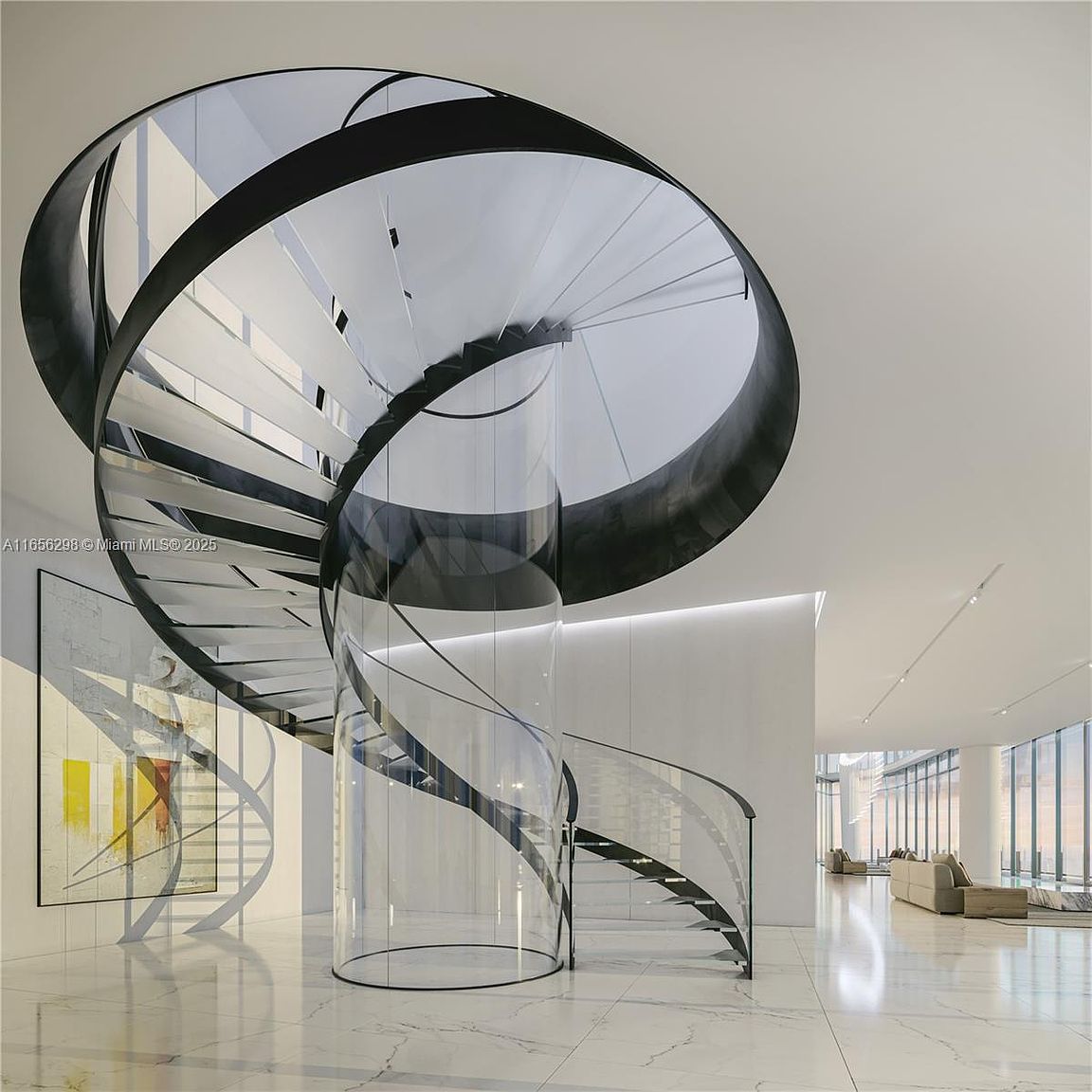 This interior shot showcases a modern, luxurious hallway featuring a striking spiral staircase with a clear cylindrical core and dark metal accents. The staircase is the focal point, complemented by the bright, open space with marble flooring and minimalist decor. The perspective is from a low angle, emphasizing the height and grandeur of the staircase and the surrounding area.